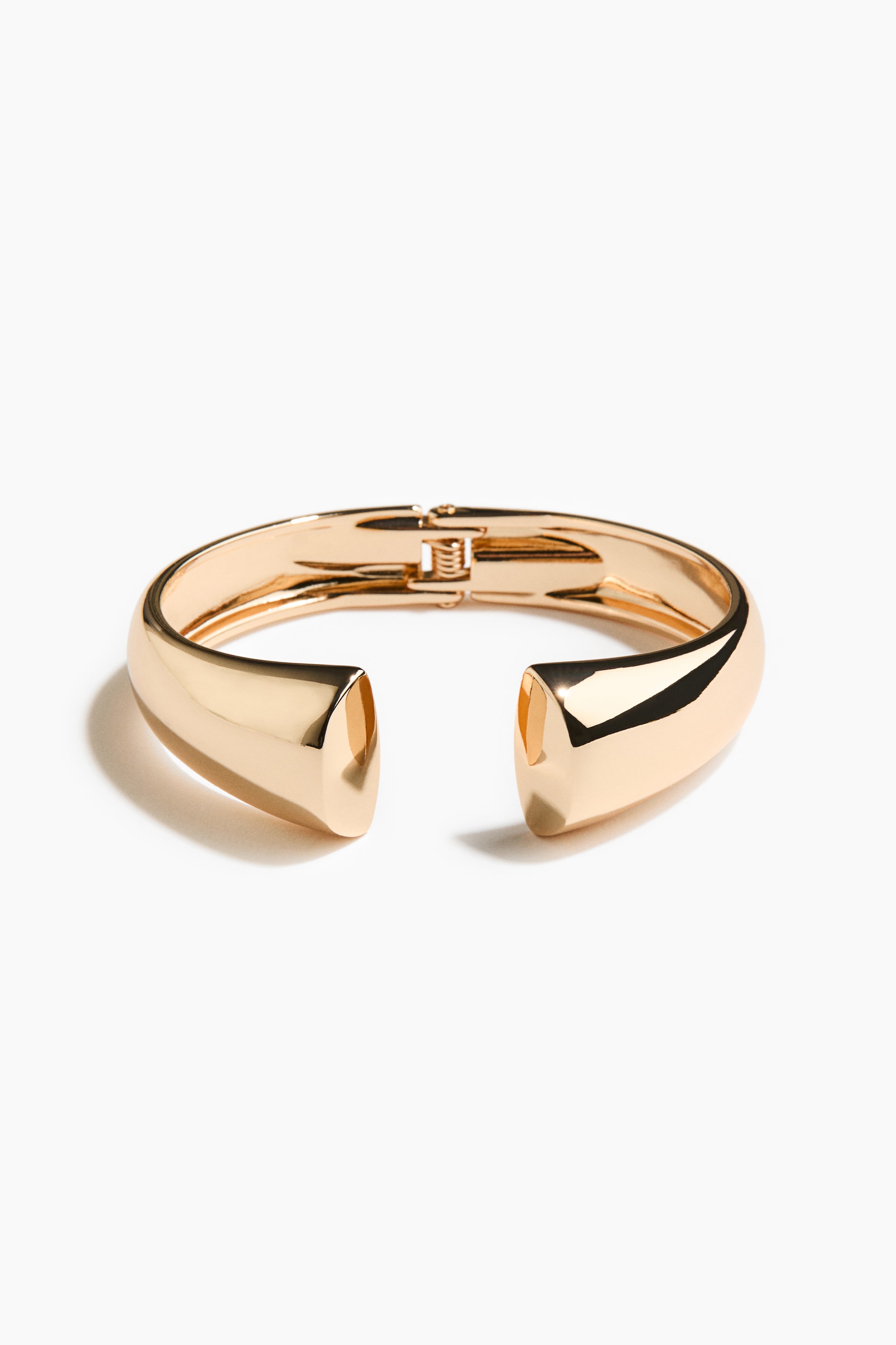 View larger image: A gold-toned hinged bangle showcases a polished, U-shaped design, with a clasp mechanism visible on one side and its open ends facing FRONT.
