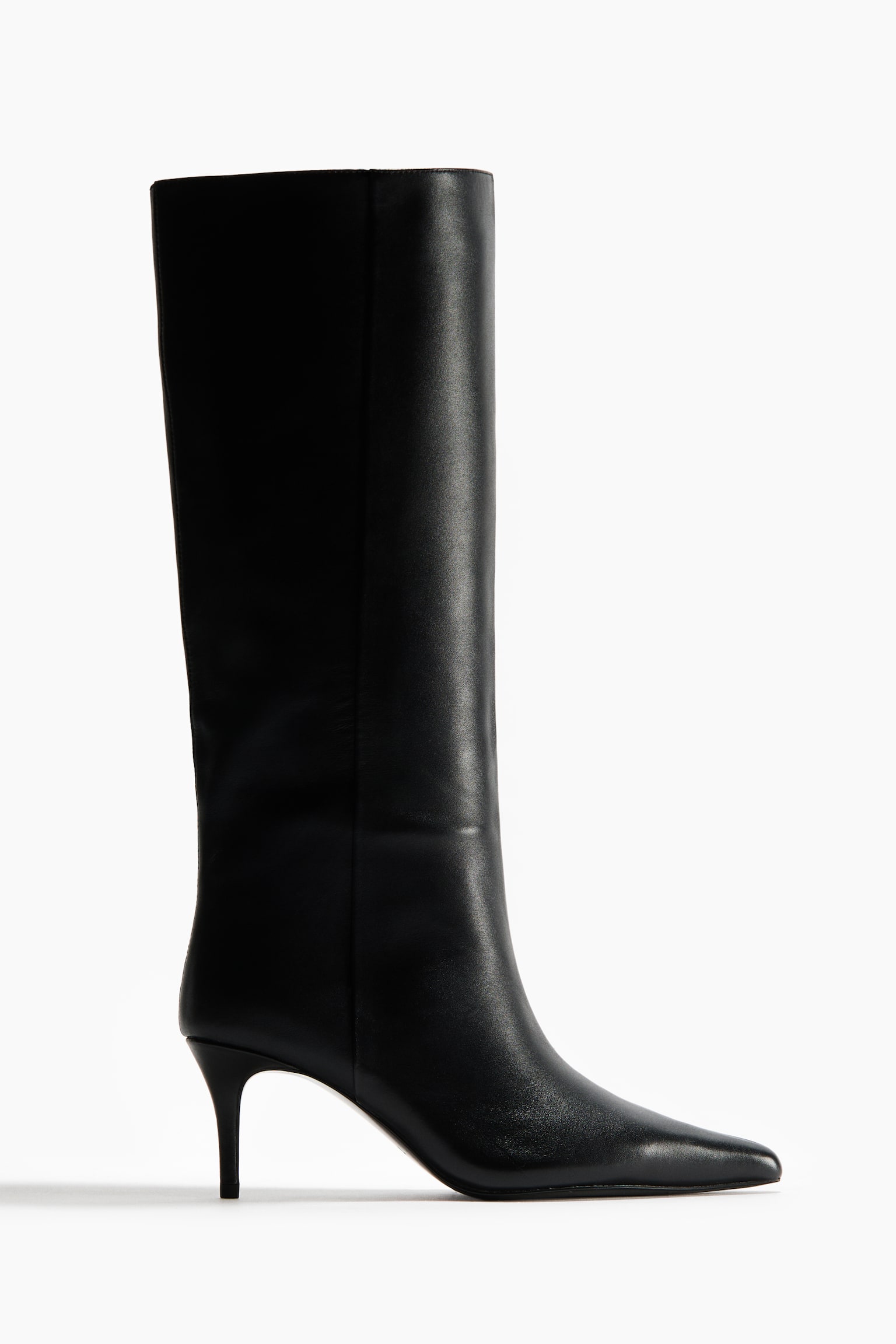 A black boot featuring a tall, smooth leather shaft, a pointed toe, and a slender kitten heel, shown in a side profile.