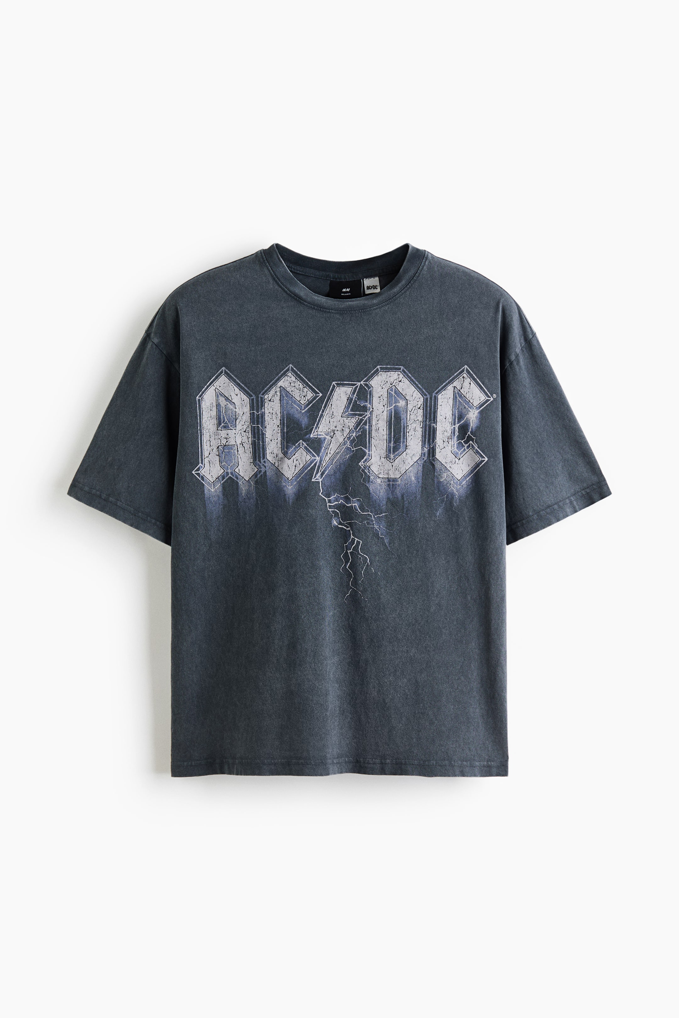 Größeres Bild anzeigen: Ein gewaschenes, dunkelgraues T-Shirt mit einem großen, abgenutzten "AC/DC"-Logo in Weiß und Hellgrau mit blauen Untertönen, das mittig auf der Vorderseite platziert ist, mit einem Blitzmotiv, das nach unten verläuft. Es präsentiert einen entspannten Schnitt mit einem gerippten Rundhalsausschnitt und kurzen Ärmeln.