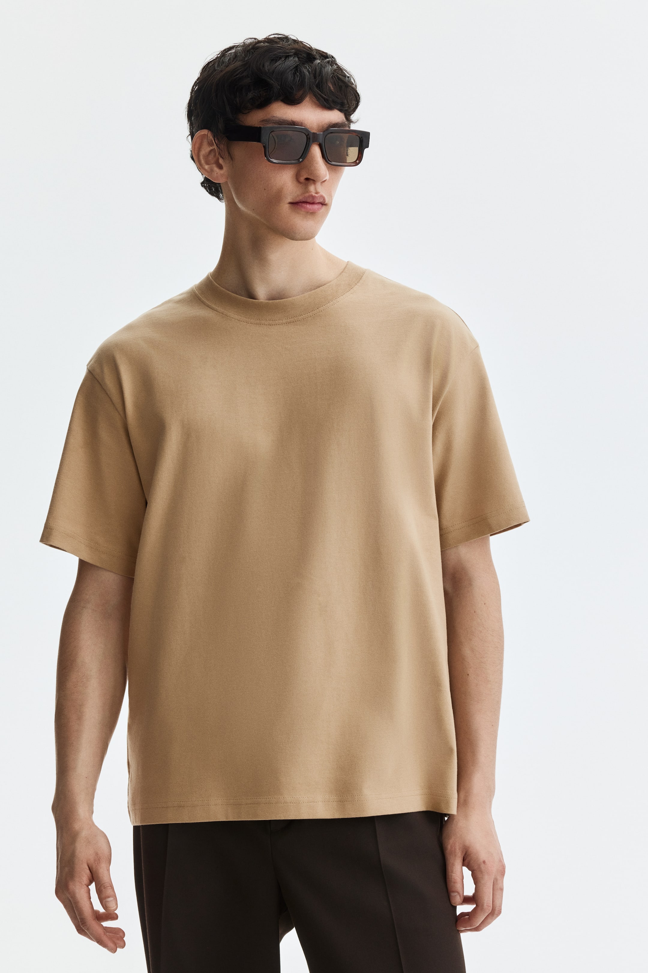 View larger image: A camel-colored short-sleeve t-shirt is shown from a front-facing angle, featuring a crew neck and a relaxed fit.