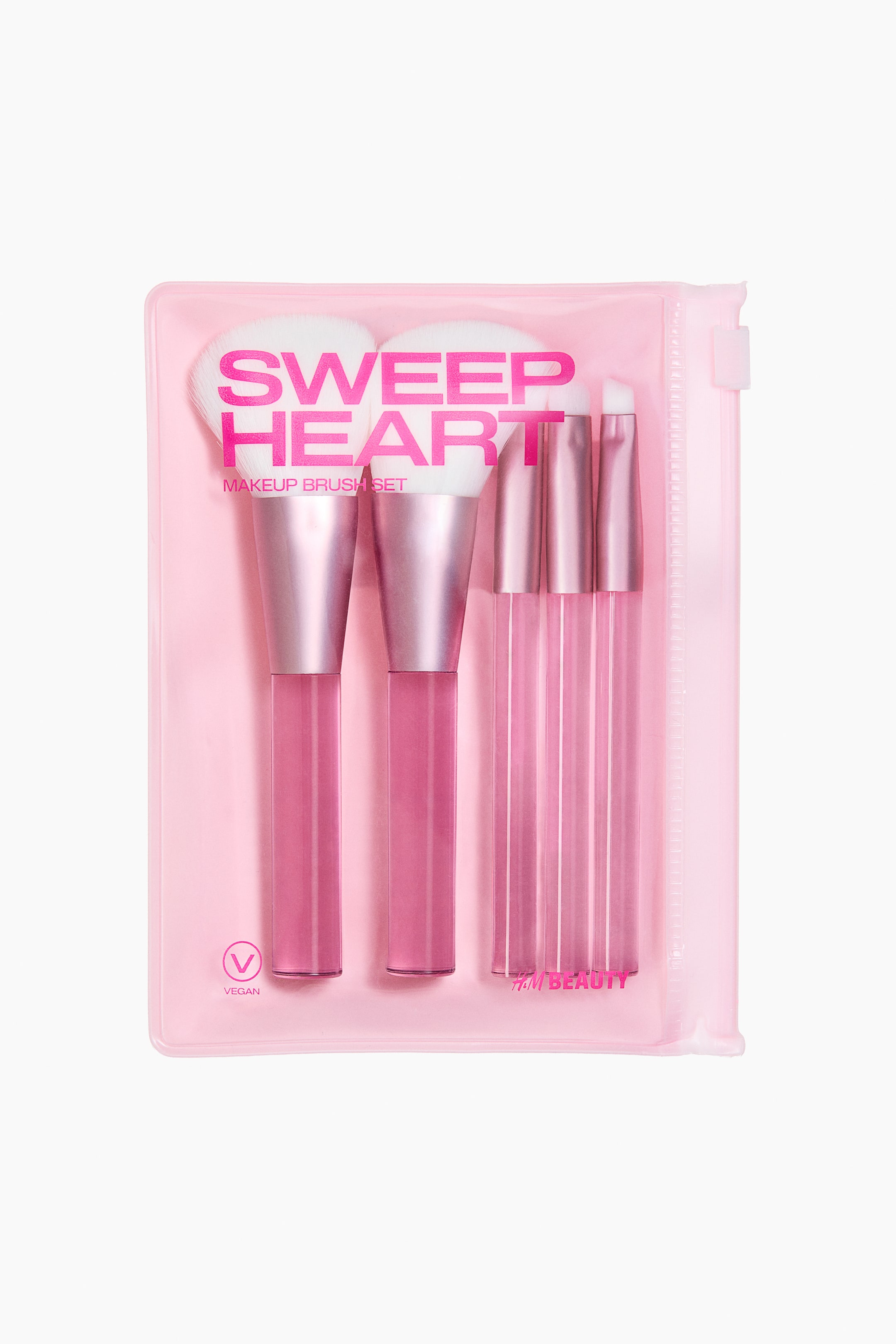 View larger image: A set of five makeup brushes is shown facing forward in a clear pink, travel-friendly zip-lock pouch. The brushes feature soft, white synthetic bristles, metallic pink ferrules, and transparent pink handles, with two larger and three smaller brushes visible. The pouch also displays the "SWEEP HEART MAKEUP BRUSH SET" branding, a vegan logo, and "H&M BEAUTY" text.