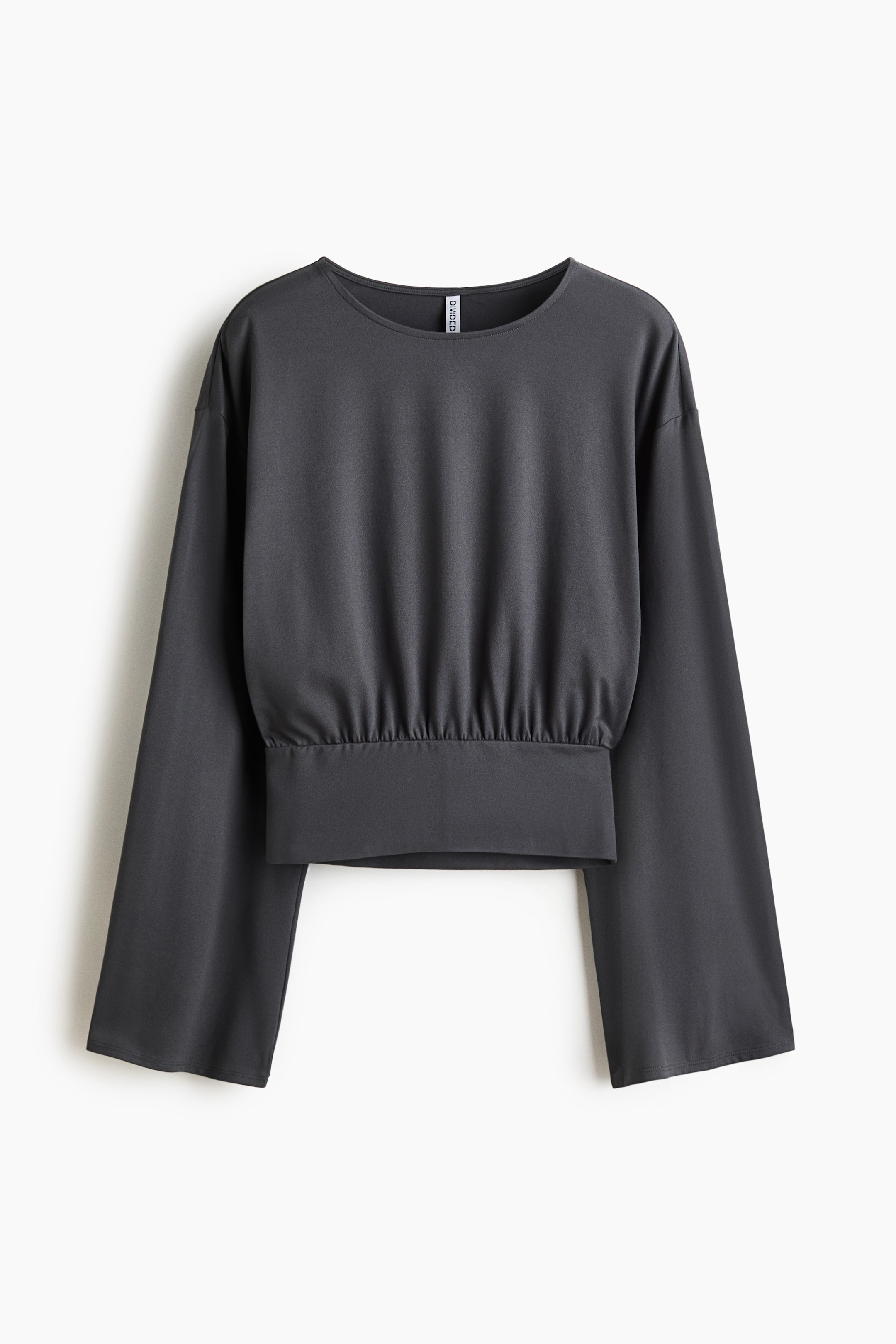 Voir une image plus grande: Un haut de couleur gris foncé, court et ample en jersey extensible présente sa vue de face. Il se caractérise par un col rond, des épaules tombantes et des manches longues. Une couture froncée et un large bord ajusté forment l'ourlet.