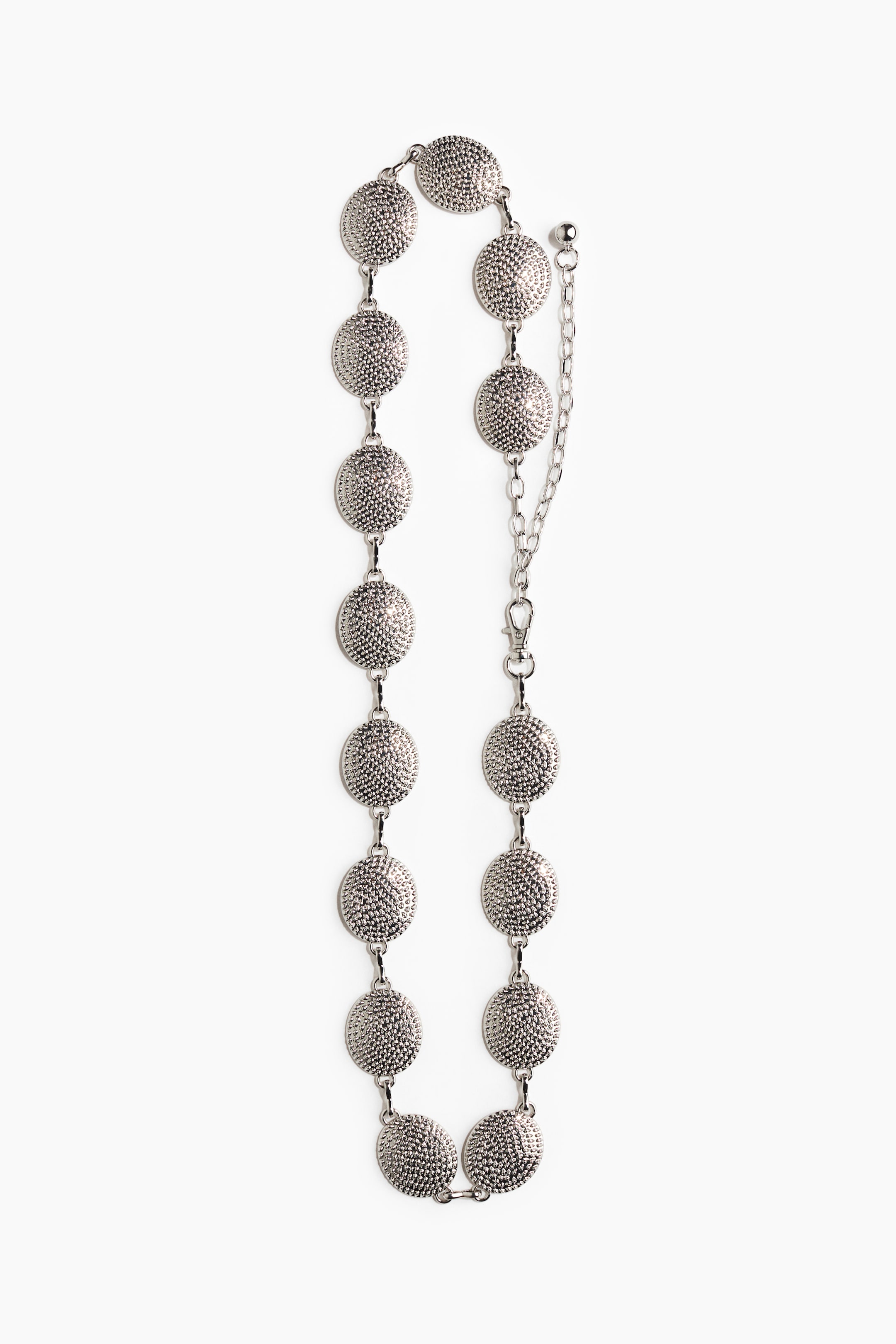 View larger image: A silver-toned chain belt featuring multiple circular, textured disc segments, each linked together. It displays an adjustable chain extension with a lobster clasp at one end, presented from a front perspective.