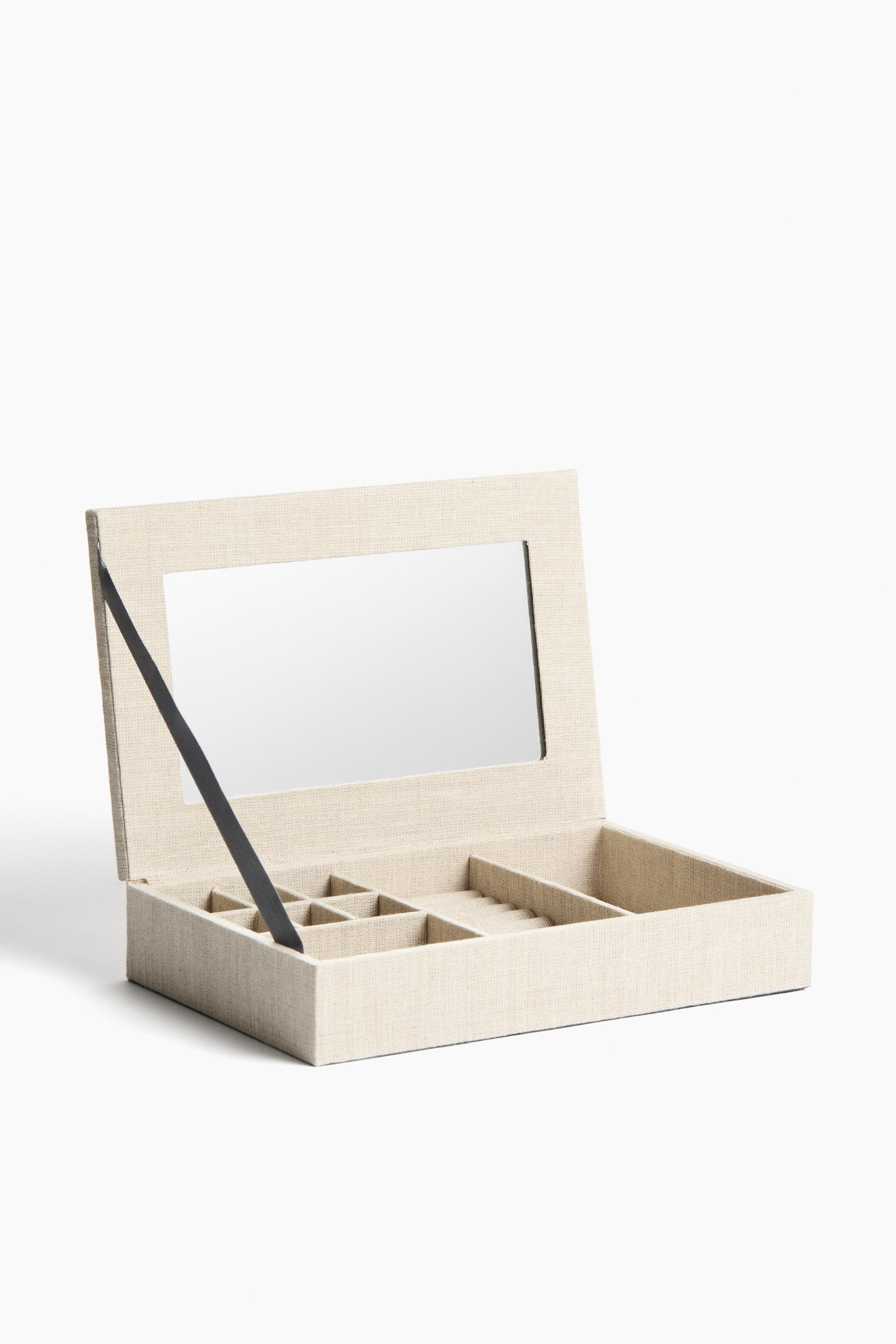 View larger image: A beige fabric jewellery box opens to the front. Its lid features a rectangular mirror and is supported by a black ribbon. The box's interior displays multiple compartments and ring rolls.