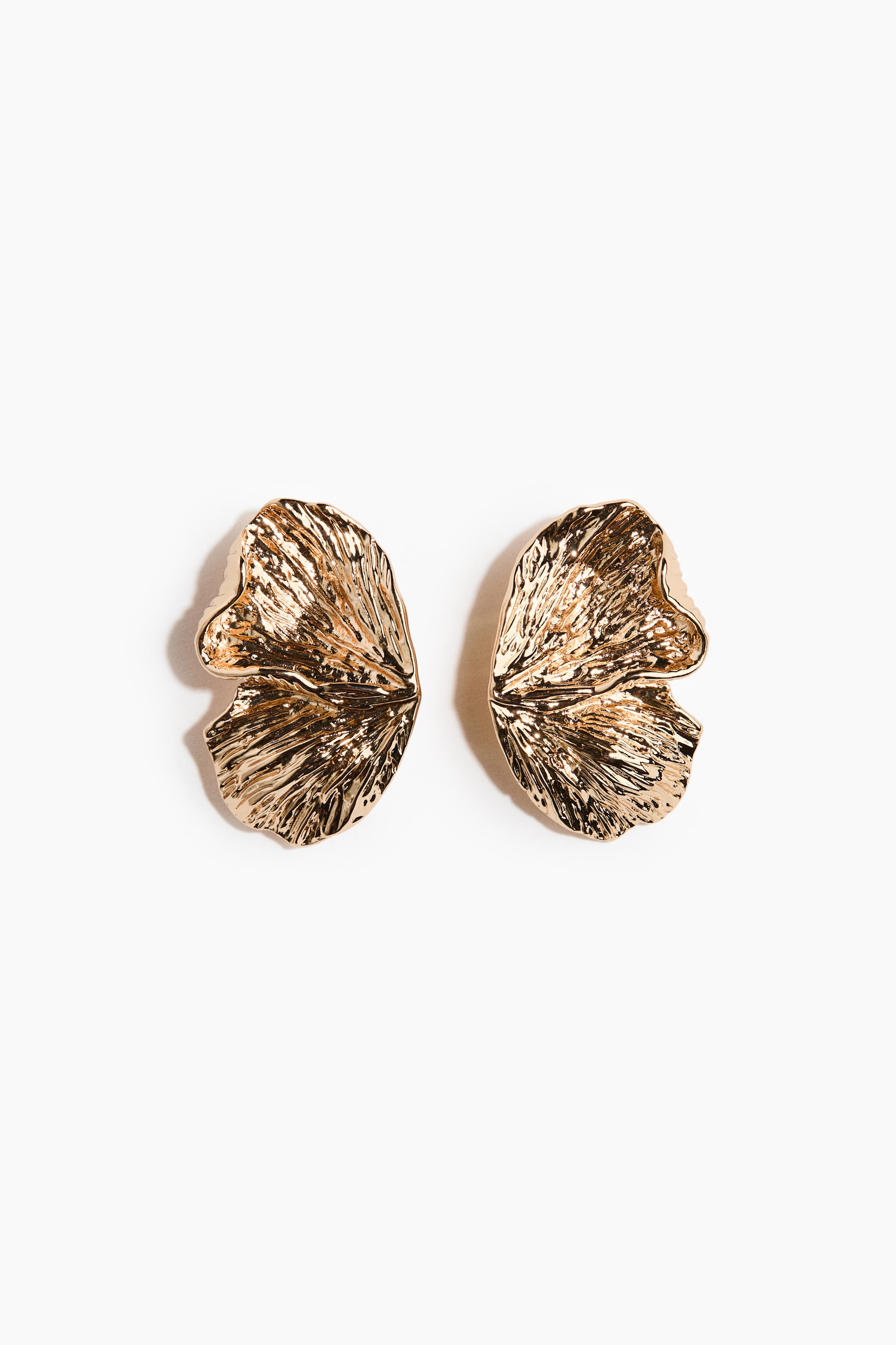 Agrandir l'image: Une paire de boucles d'oreilles dorées présente une forme organique rappelant une feuille froissée. Chaque boucle d'oreille arbore une surface très texturée et réfléchissante, orientée vers l'avant pour mettre en valeur sa forme tridimensionnelle.