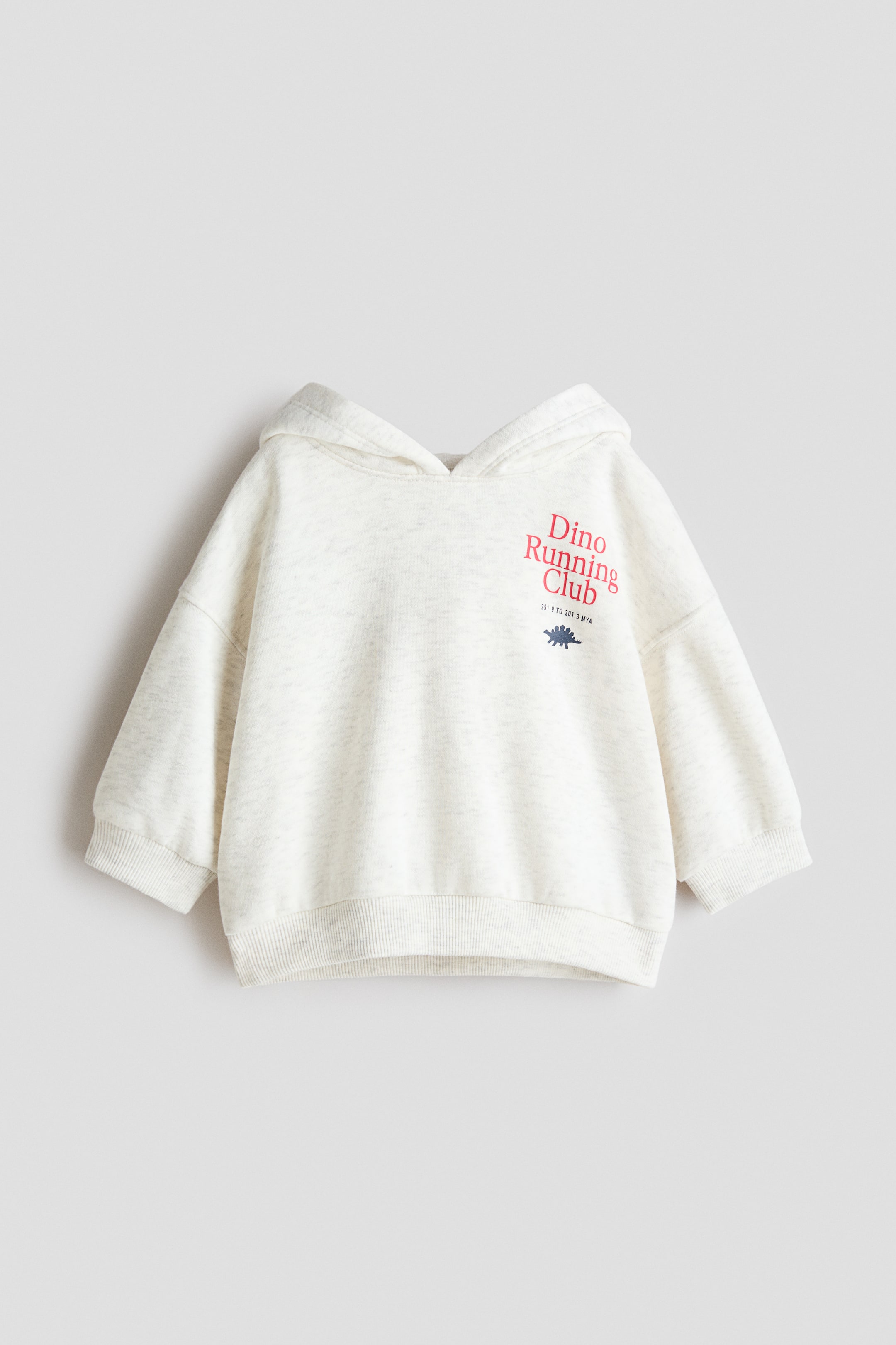 拡大画像を表示: 薄いグレーのマール地のフーディーは、フード、リブ付きの袖口が付いた長袖、およびリブ付きの裾が特徴的です。胸には赤い「Dino Running Club」のグラフィックが表示され、その下には小さな青い恐竜のイラストがあります。