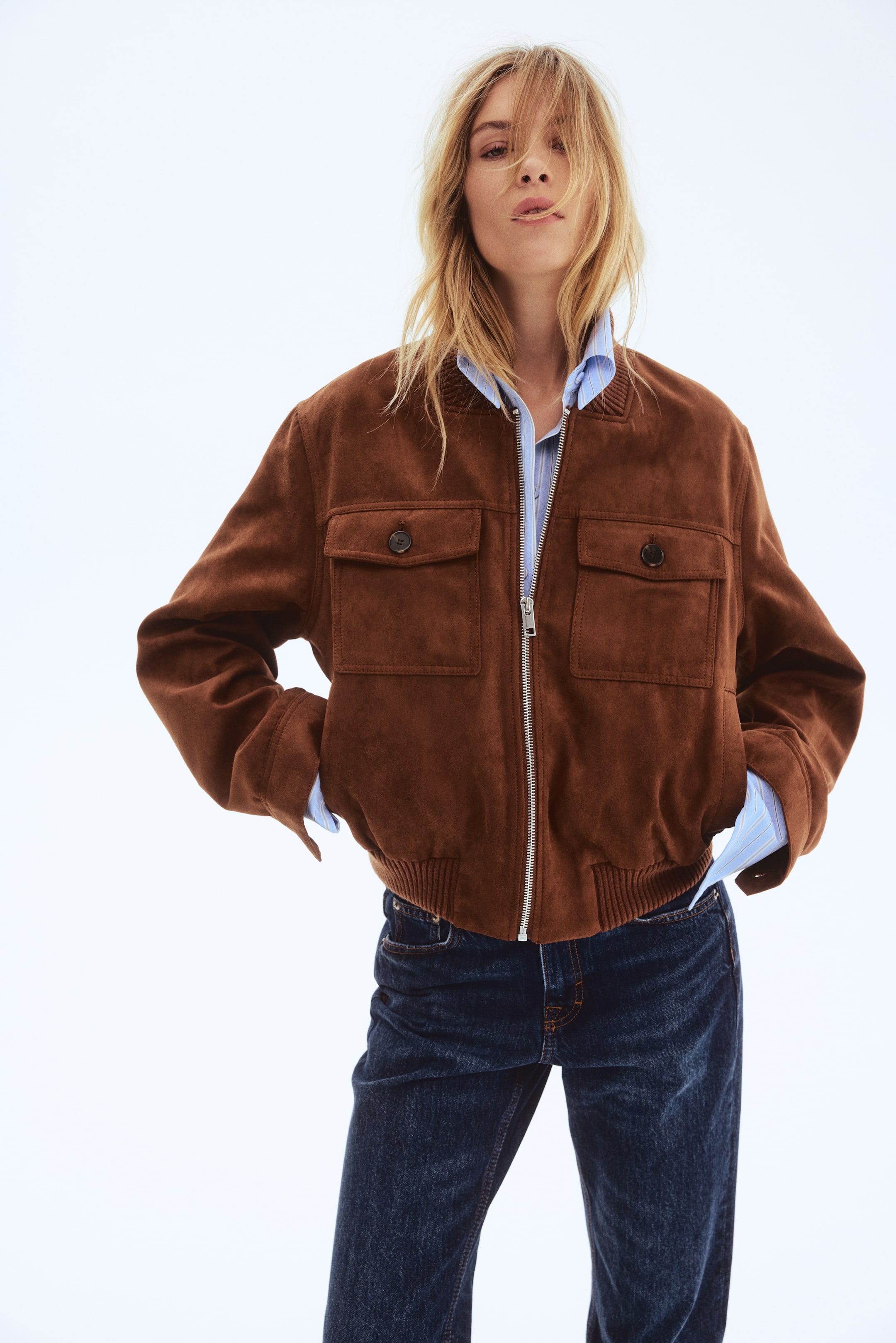 Prikaži veću sliku: Predstavlja se bomber jakna od smeđe antilop tkanine, sa prednjim delom na potpuno kopčanje sa srebrnim rajsferšlusom, dva džepa sa preklopom na grudima sa dugmadima, i rebrastim detaljima na kragni, manžetnama i porubu.