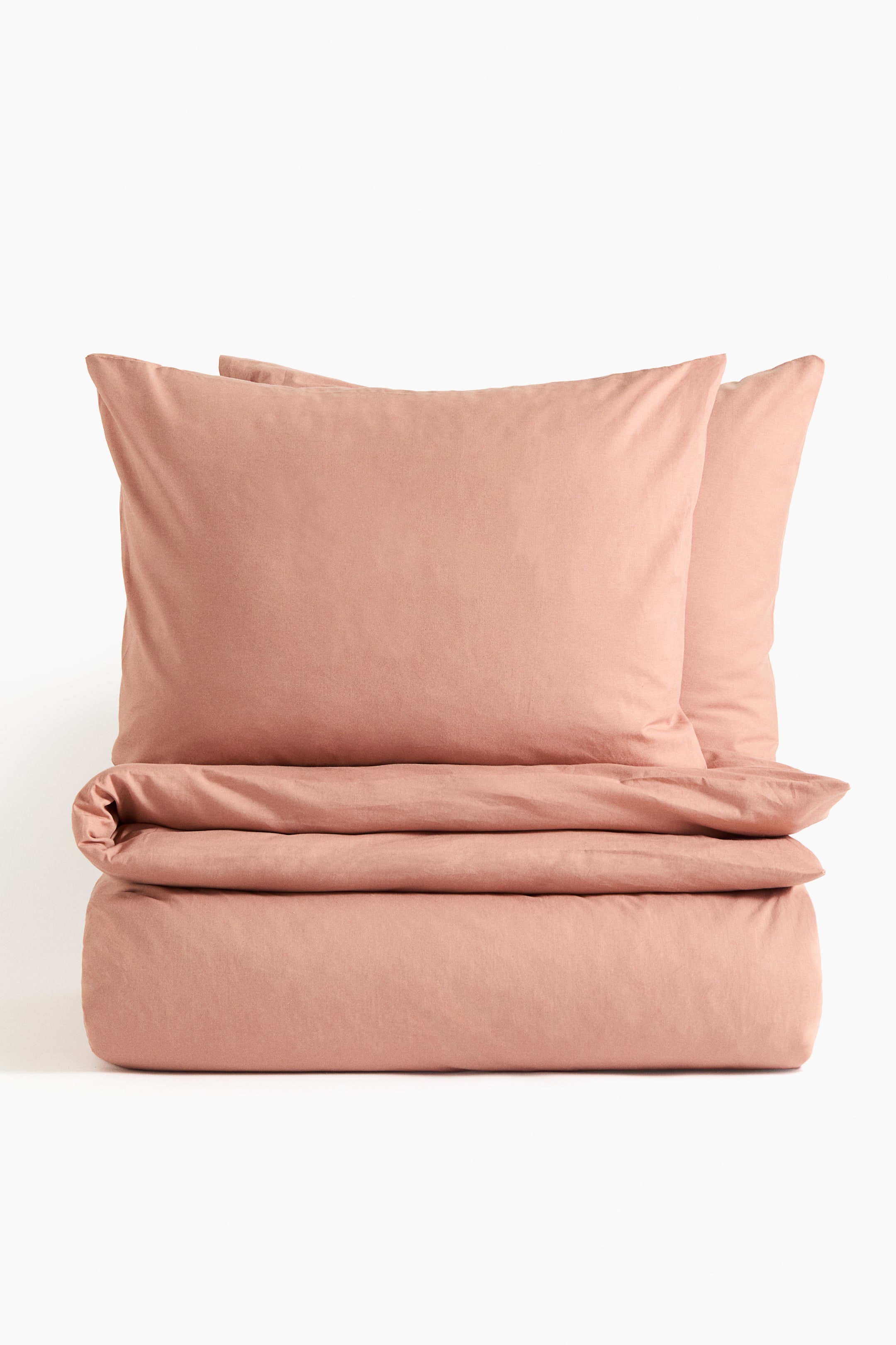 View larger image: A pinkish-brown duvet cover set is shown from the front, with the duvet cover folded horizontally at the bottom and two pillowcases standing upright behind it.