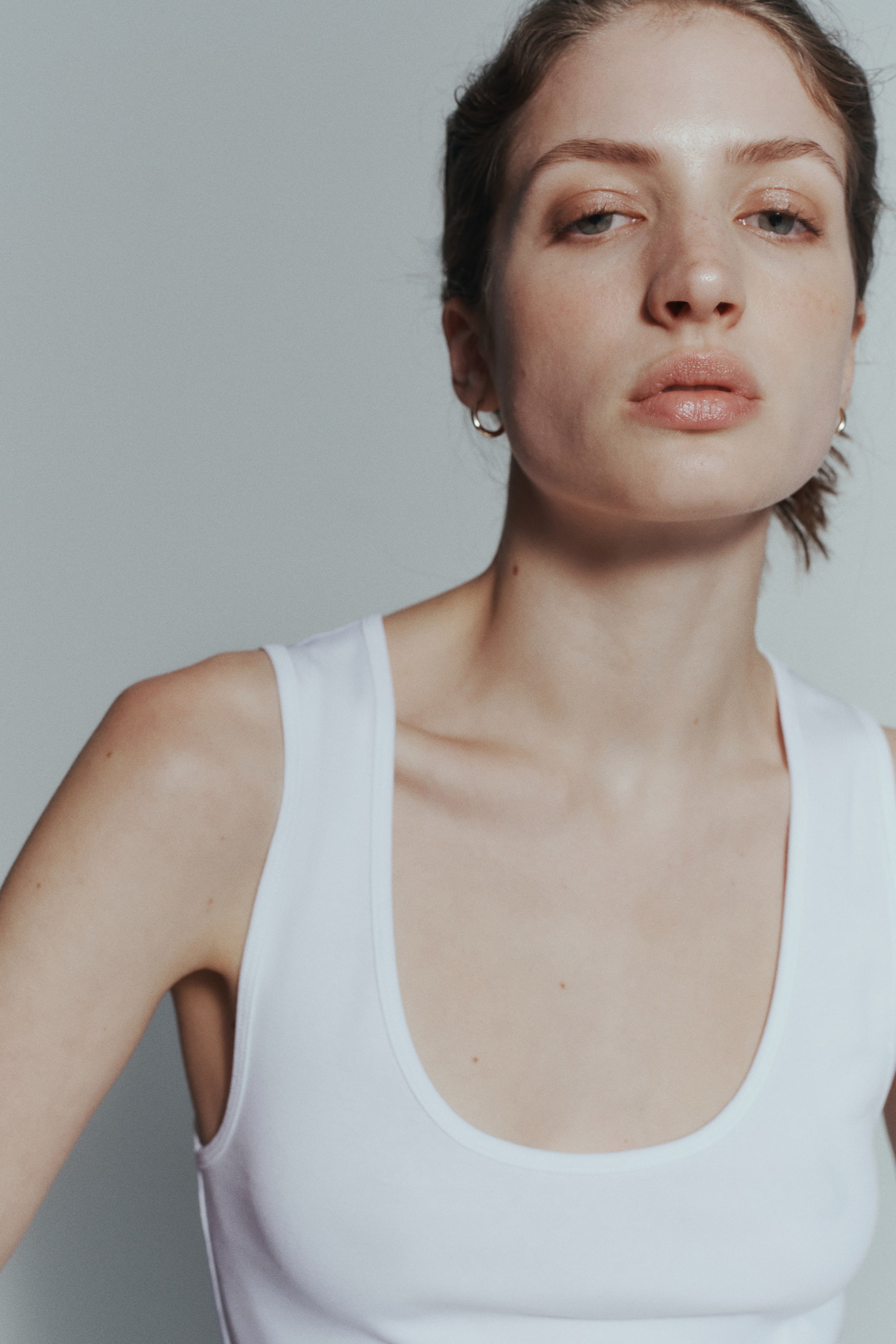 Agrandir l'image: Un débardeur blanc ajusté avec un col rond est porté par le mannequin.