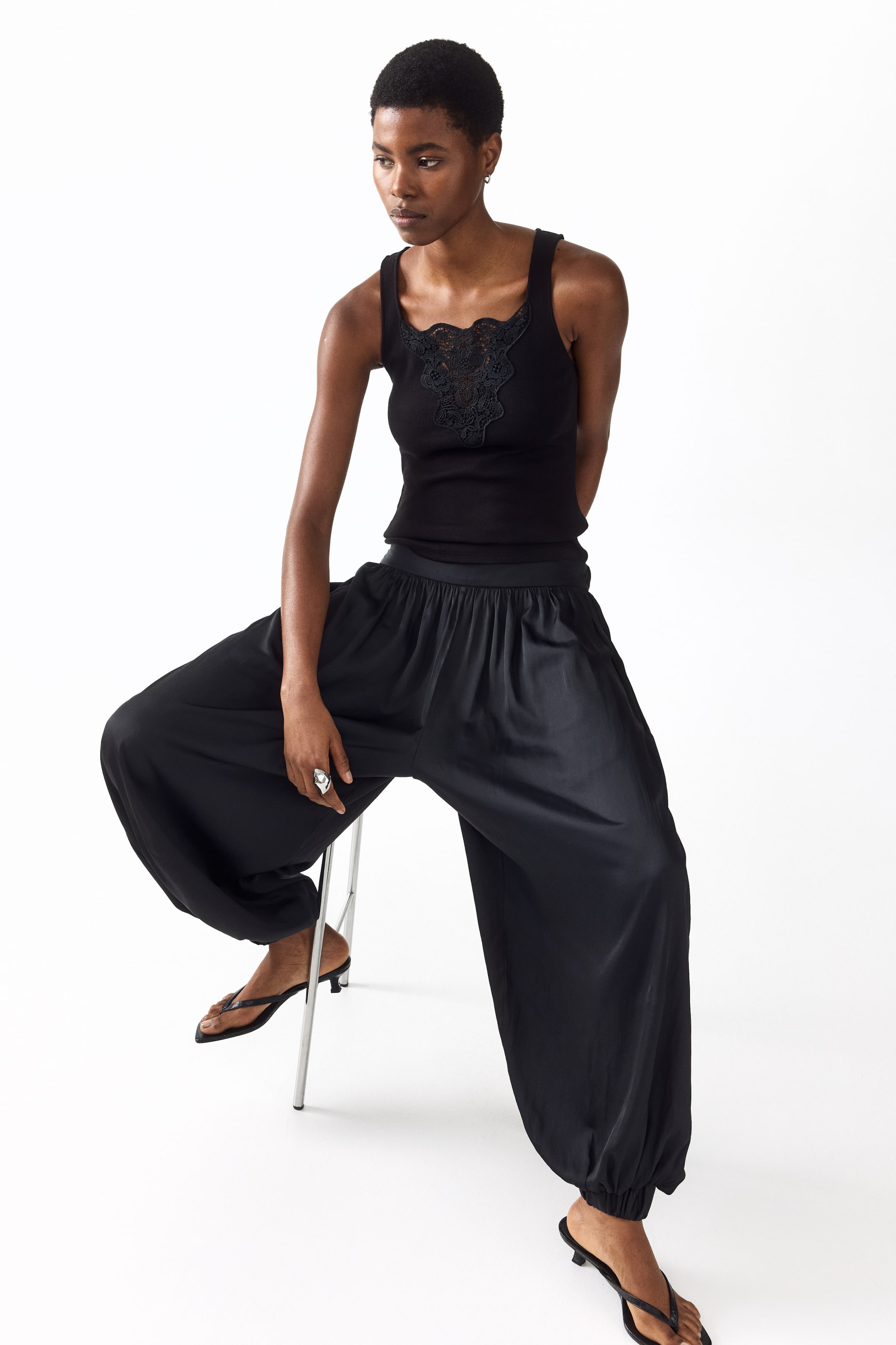 Zobacz większy obraz: Dopasowany, bezrękawnikowy top z prążkowanej dzianiny bawełnianej, z kwadratowym dekoltem, koronkową wstawką w kształcie litery V z falistymi brzegami z przodu oraz prostym dołem, noszony przez modelkę.