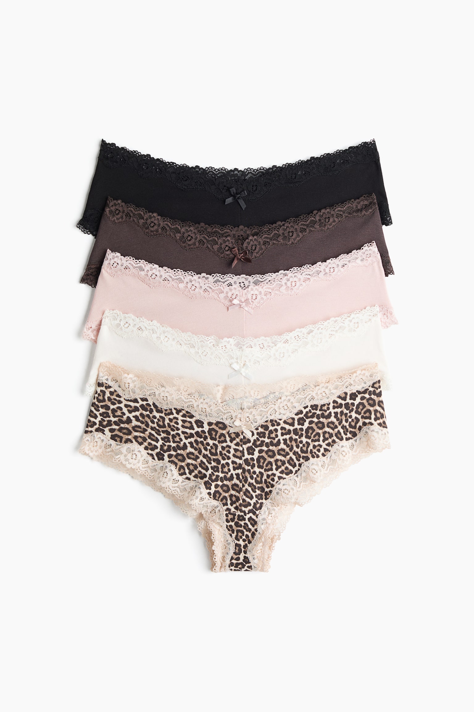 Five pairs of low-rise cotton jersey briefs are arranged in an overlapping vertical stack, front-facing, featuring a V-shaped waist, delicate lace trim, and a small bow at the centre. The selection showcases solid black, dark brown, light pink, off-white, and leopard print designs, each with matching lace details.