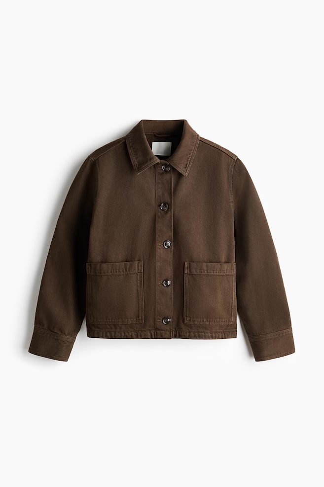 A brown jacket is shown in a front view, featuring a pointed collar and a button-front closure with five dark buttons. Two large rectangular patch pockets are visible on the lower front, and the long sleeves end in plain cuffs. - 1