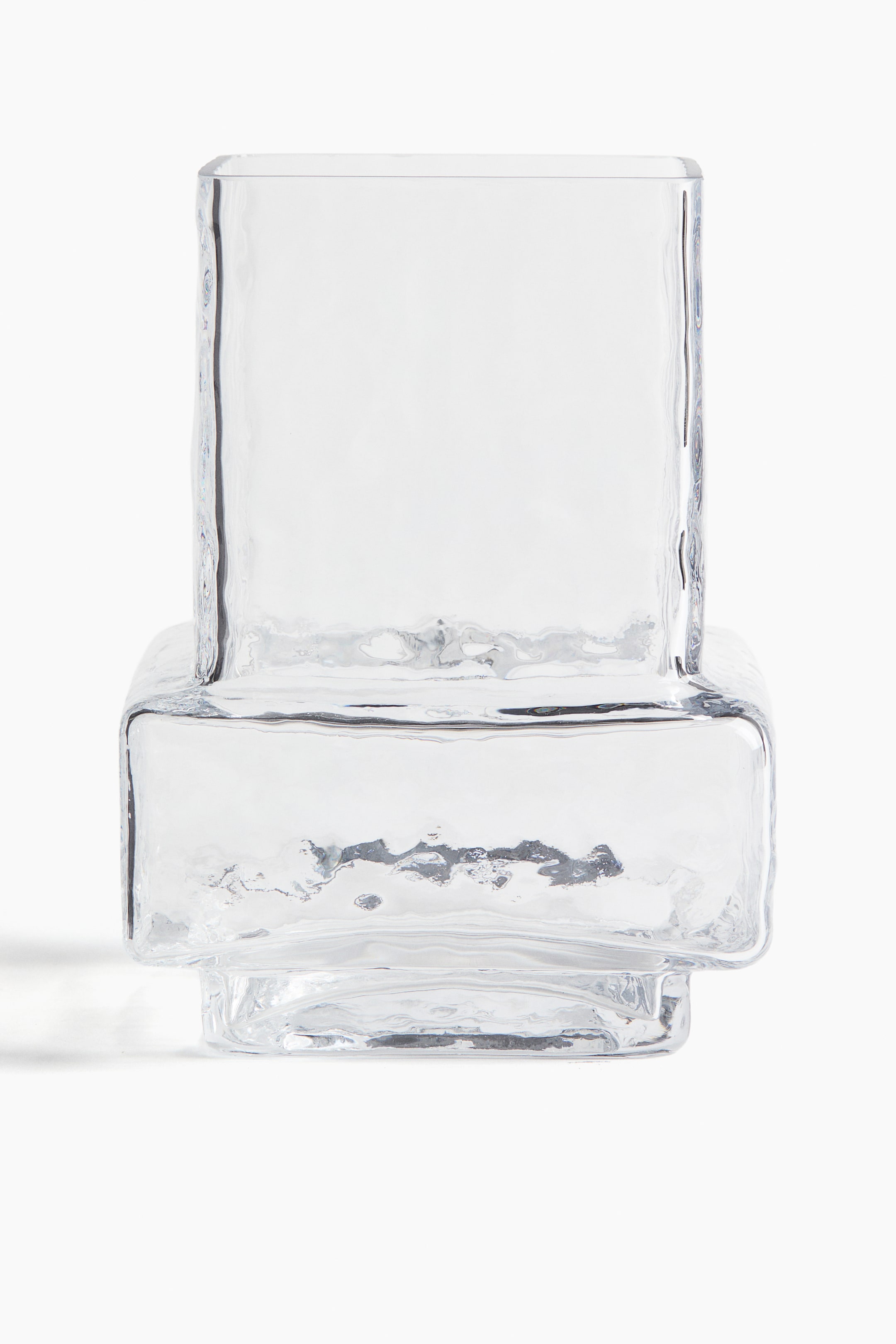 Agrandir l'image: Un vase en verre transparent, vu de face, présente un design géométrique en gradins. Sa surface irrégulière et texturée recouvre ses formes rectangulaires empilées.