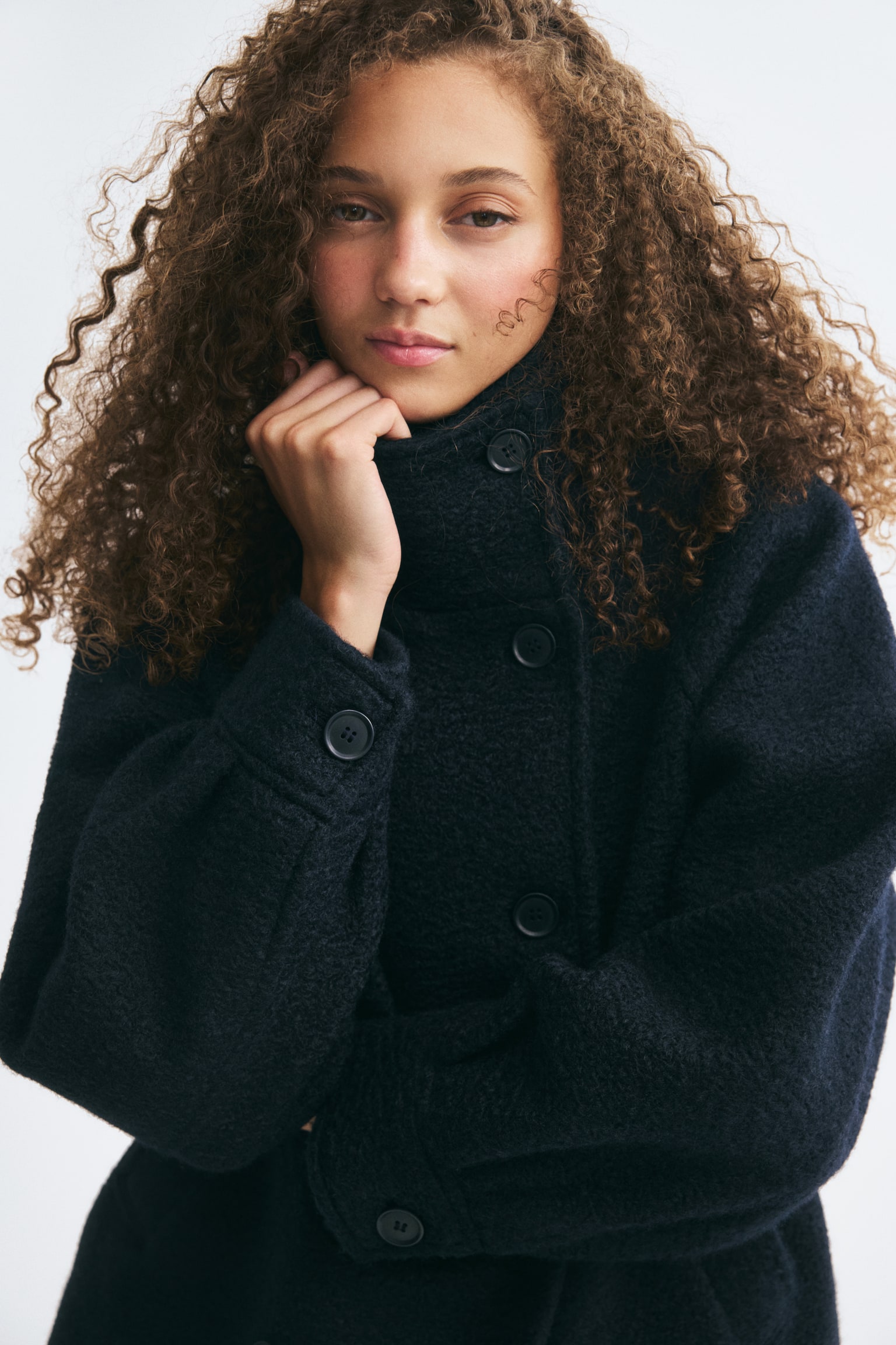 Une veste croisÃ©e en tissu feutrÃ© texturÃ© bleu marine foncÃ© est prÃ©sentÃ©e de face, mettant en valeur un col cheminÃ©e haut boutonnÃ© et une fermeture croisÃ©e Ã  boutons. Elle se distingue par de longues manches raglan avec larges poignets et des poches passepoilÃ©es obliques sur le devant. - 1
