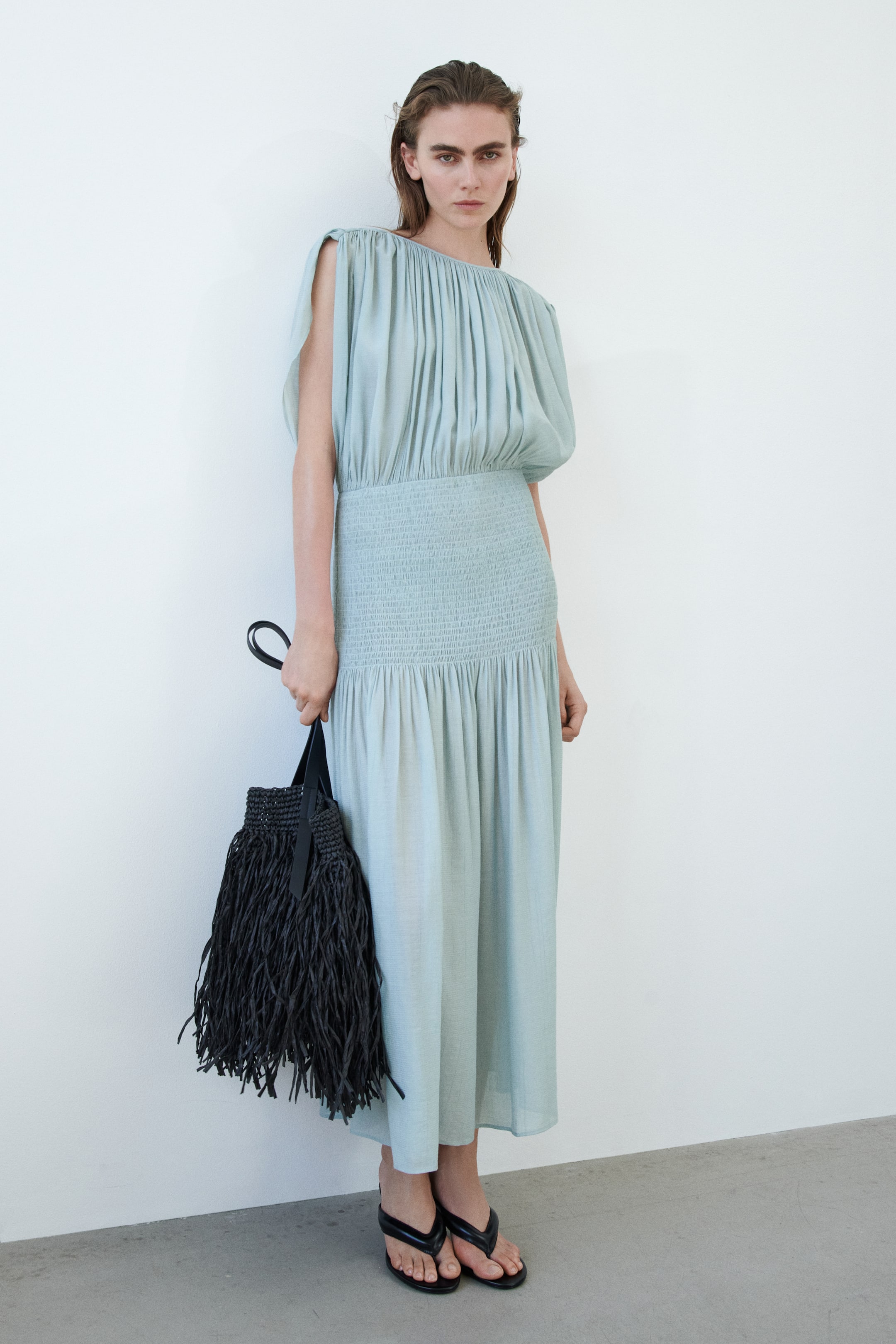 Ampliar la imagen: Un vestido midi de color azul verdoso pálido presenta un escote redondo fruncido y mangas cortas drapeadas. Su cuerpo se transforma en una cintura fruncida, que lleva a una falda fluida y recogida.