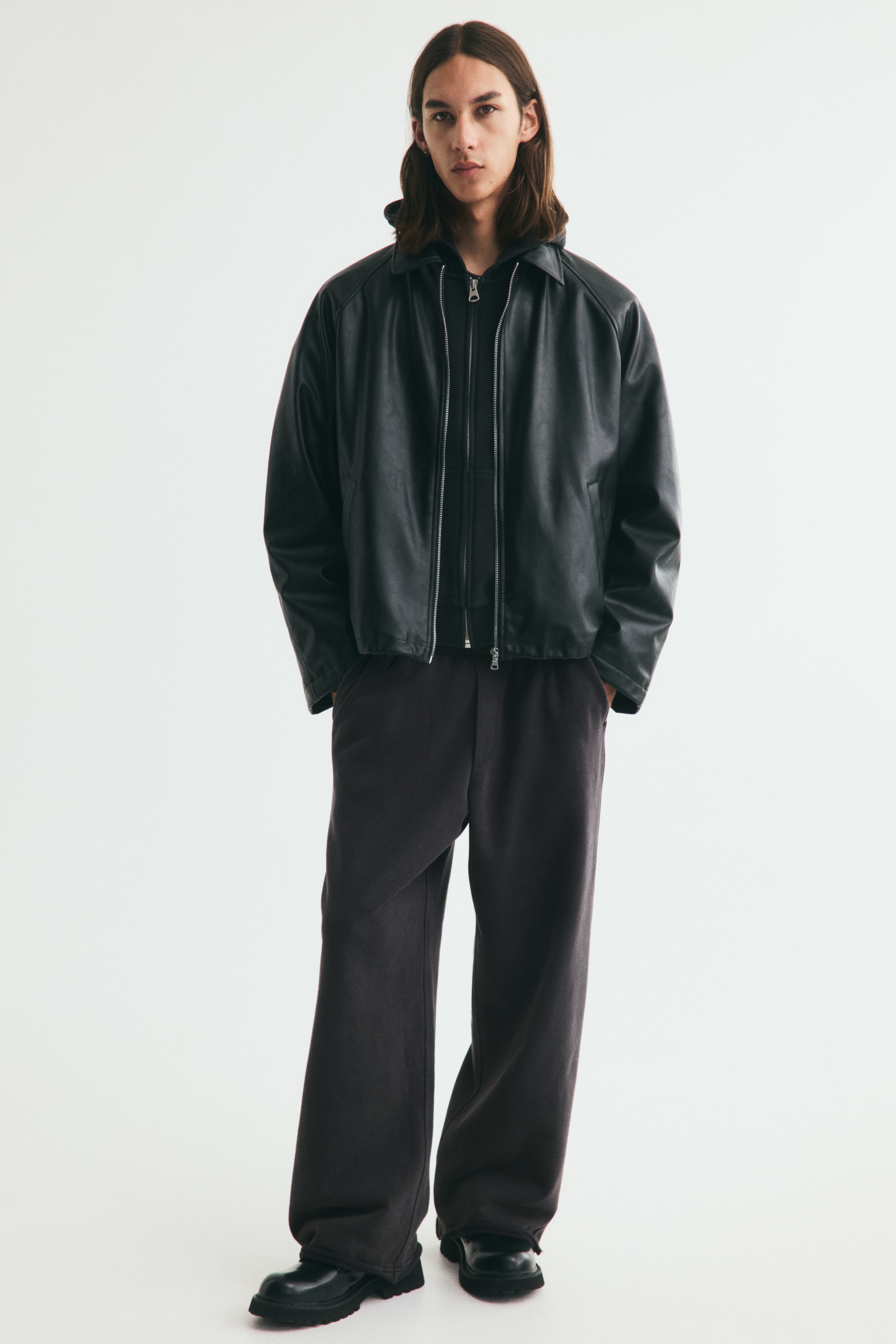 Quần jogger ống rộng màu đen đã giặt được chụp từ phía trước, có cạp chun, hai túi bên và gấu quần cắt thô.