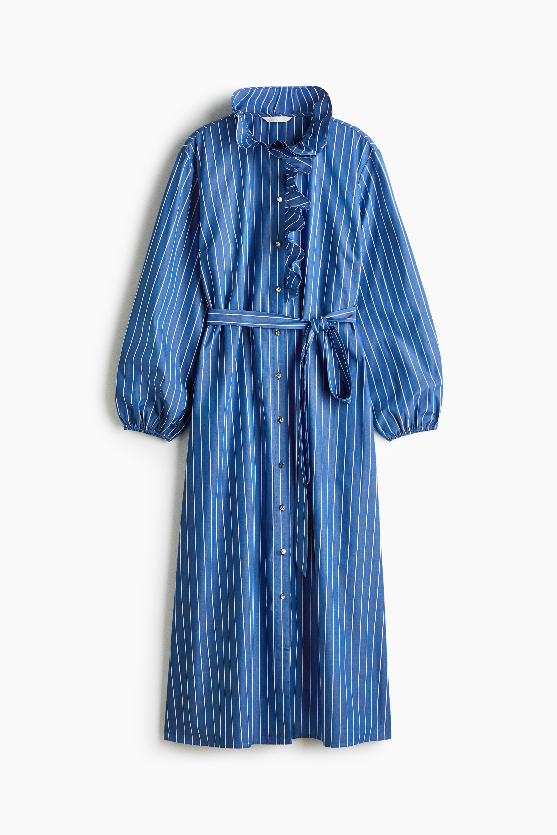 The model is wearing a blue and white vertically striped long dress featuring a ruffled collar and matching ruffles along the front button-down placket. The dress is styled with voluminous balloon sleeves and a matching fabric tie belt at the waist.
