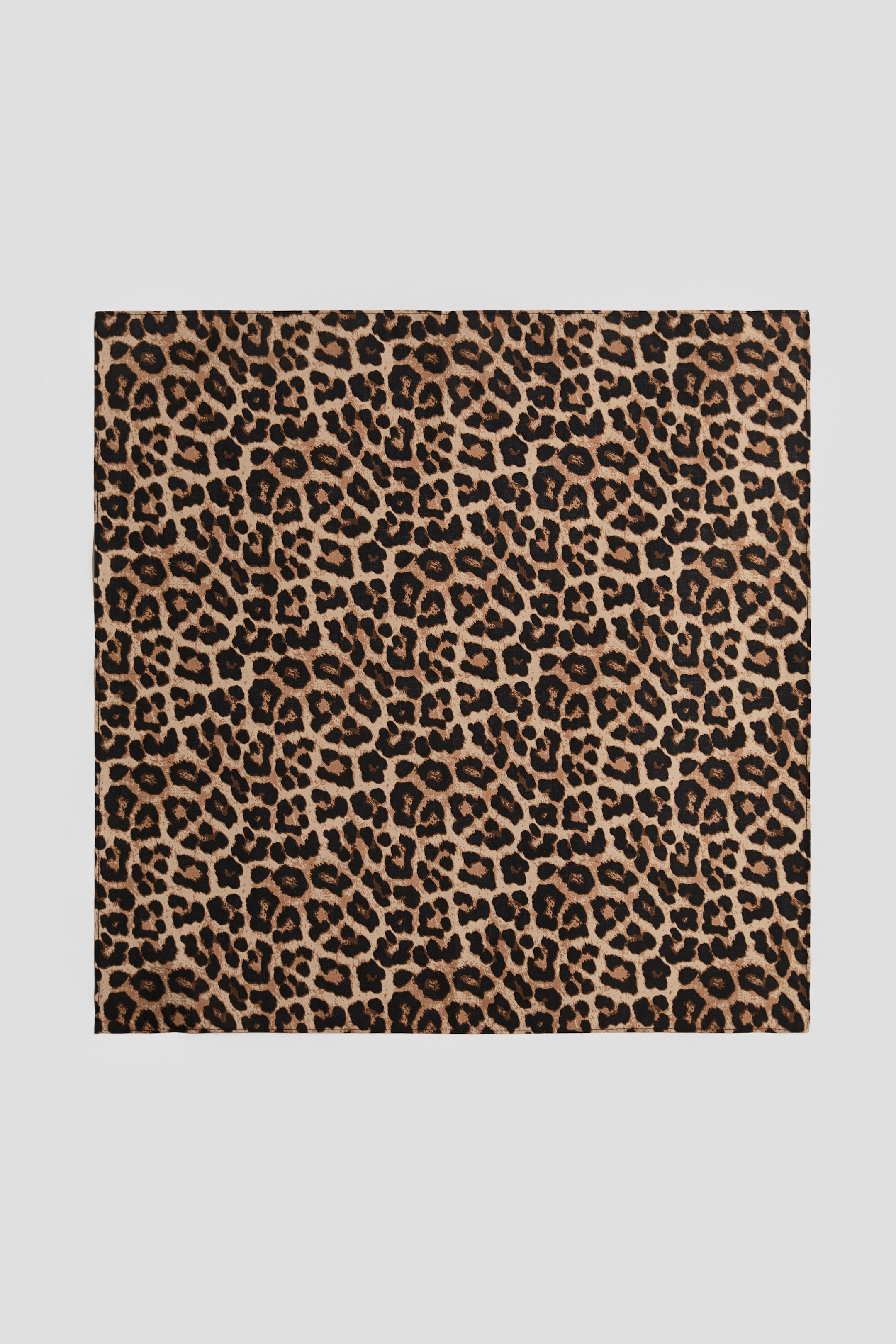 Visualizza l'immagine ingrandita: Una sciarpa quadrata in tessuto di cotone stampato è appoggiata in piano frontalmente, mostrando una stampa leopardata all-over nei toni del marrone, nero e beige.