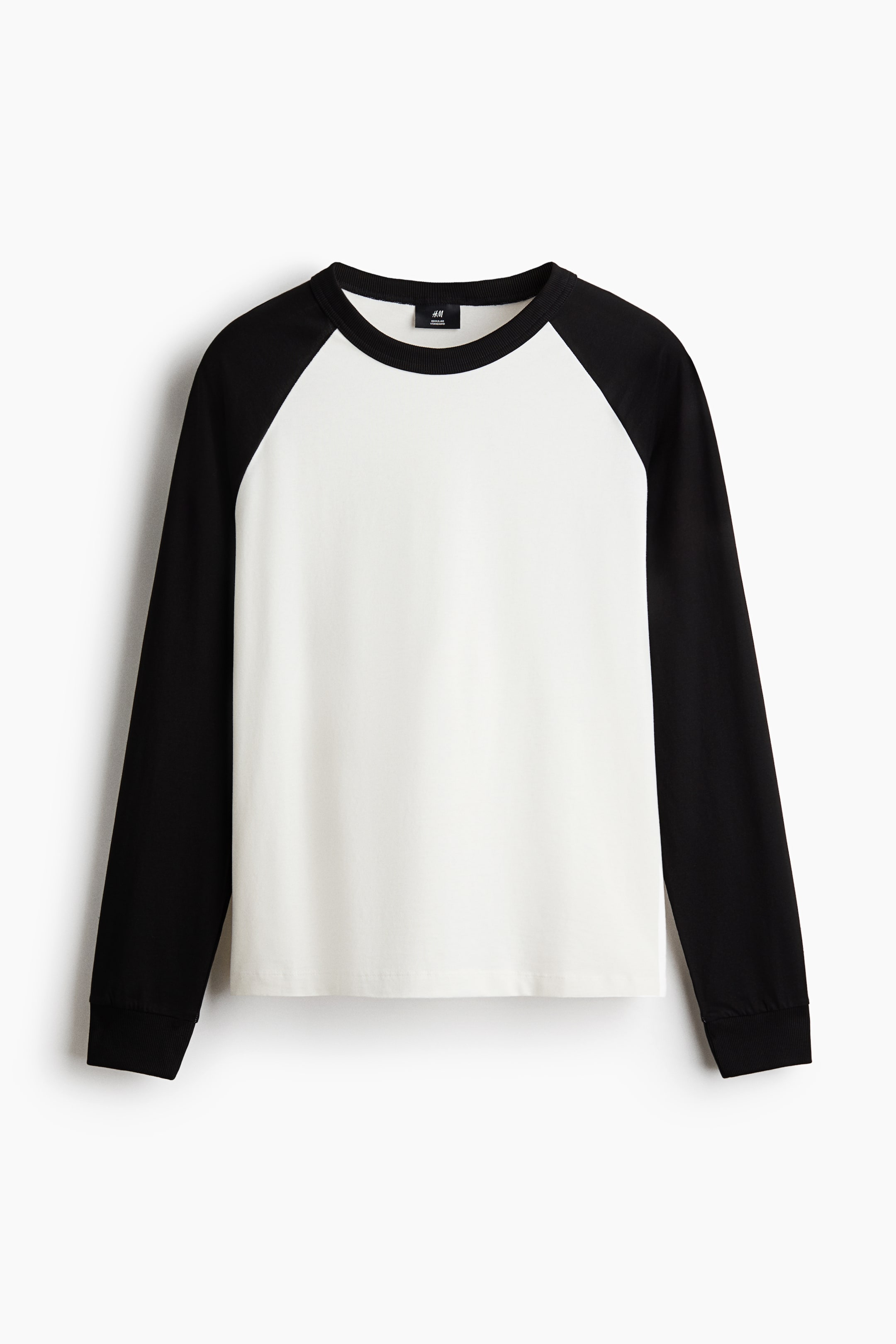 Grotere afbeelding bekijken: Een T-shirt met lange mouwen in raglanstijl wordt van voren getoond, met een wit lijf en contrasterende zwarte lange mouwen en een zwarte ronde hals met ribboord. Het shirt is ontworpen met een rechte zoom en geribde boorden aan de mouwen en heeft een klassieke regular fit.