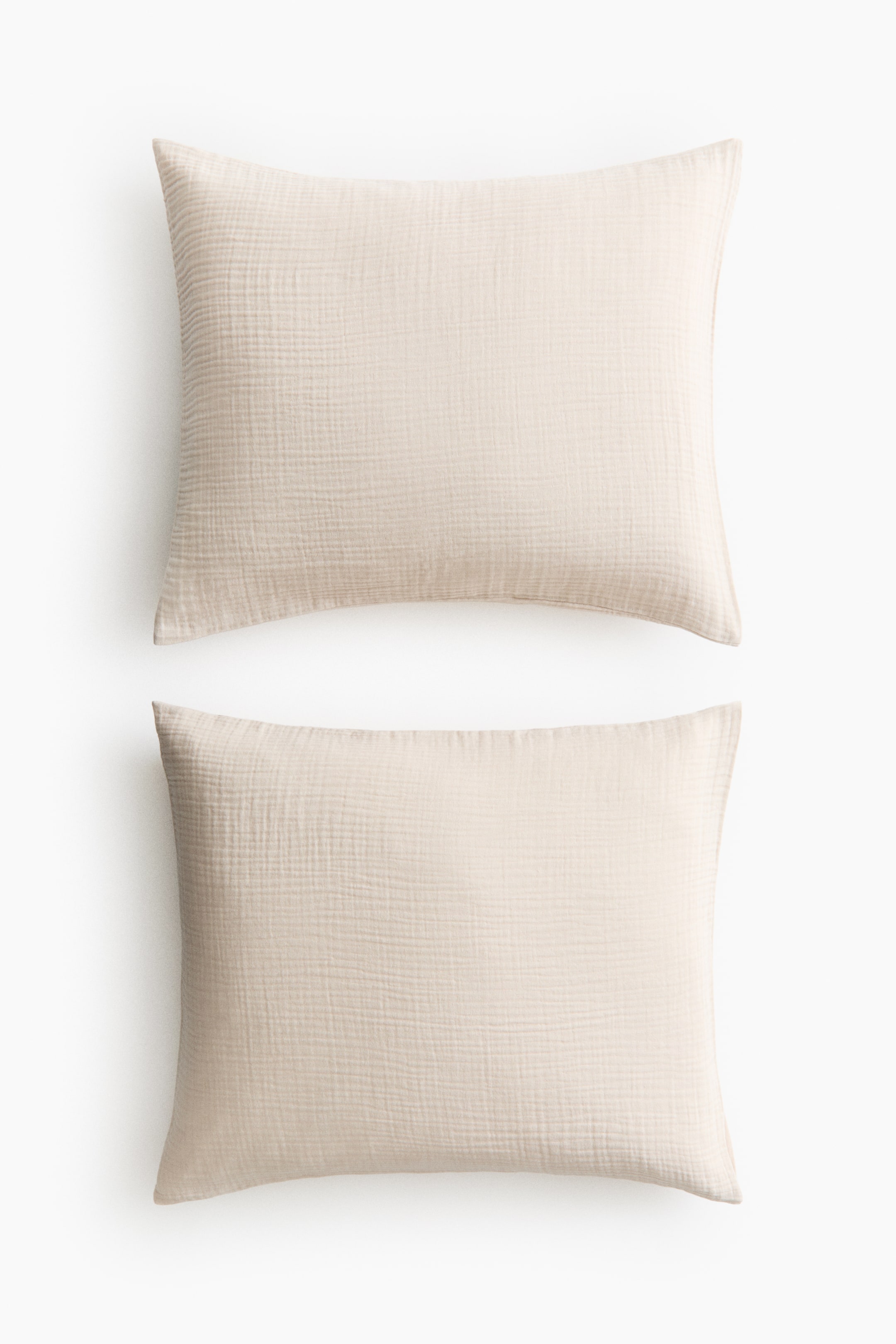 View larger image: Two light beige rectangular cushions are lying horizontally, one atop the other, each showcasing a distinct crinkled texture.