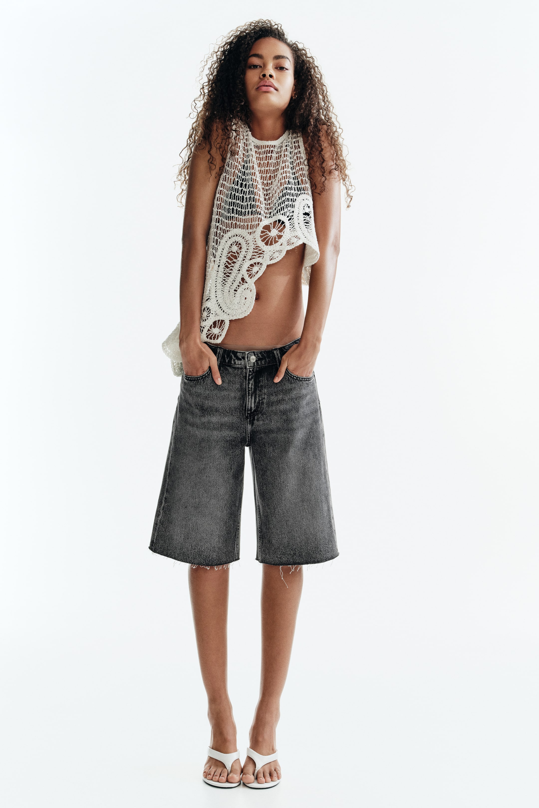 View larger image: Front-facing gray denim culotte shorts feature a wide leg, a faded gray wash, and raw, unfinished hems. Visible front pockets are shown.