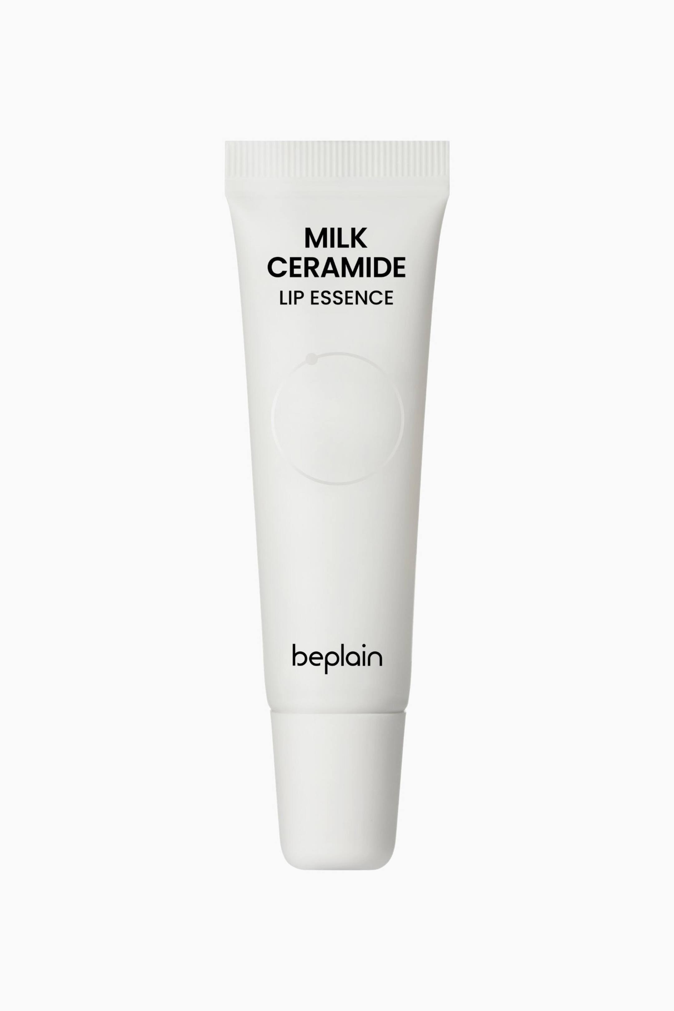 Visa större bild: En vit tub med läppessens står upprätt och vänd framåt, med "MILK CERAMIDE LIP ESSENCE" tryckt i svarta versaler högst upp och "beplain" i gemener längst ner. En diskret cirkelkontur med en central punkt syns i mitten av tuben.
