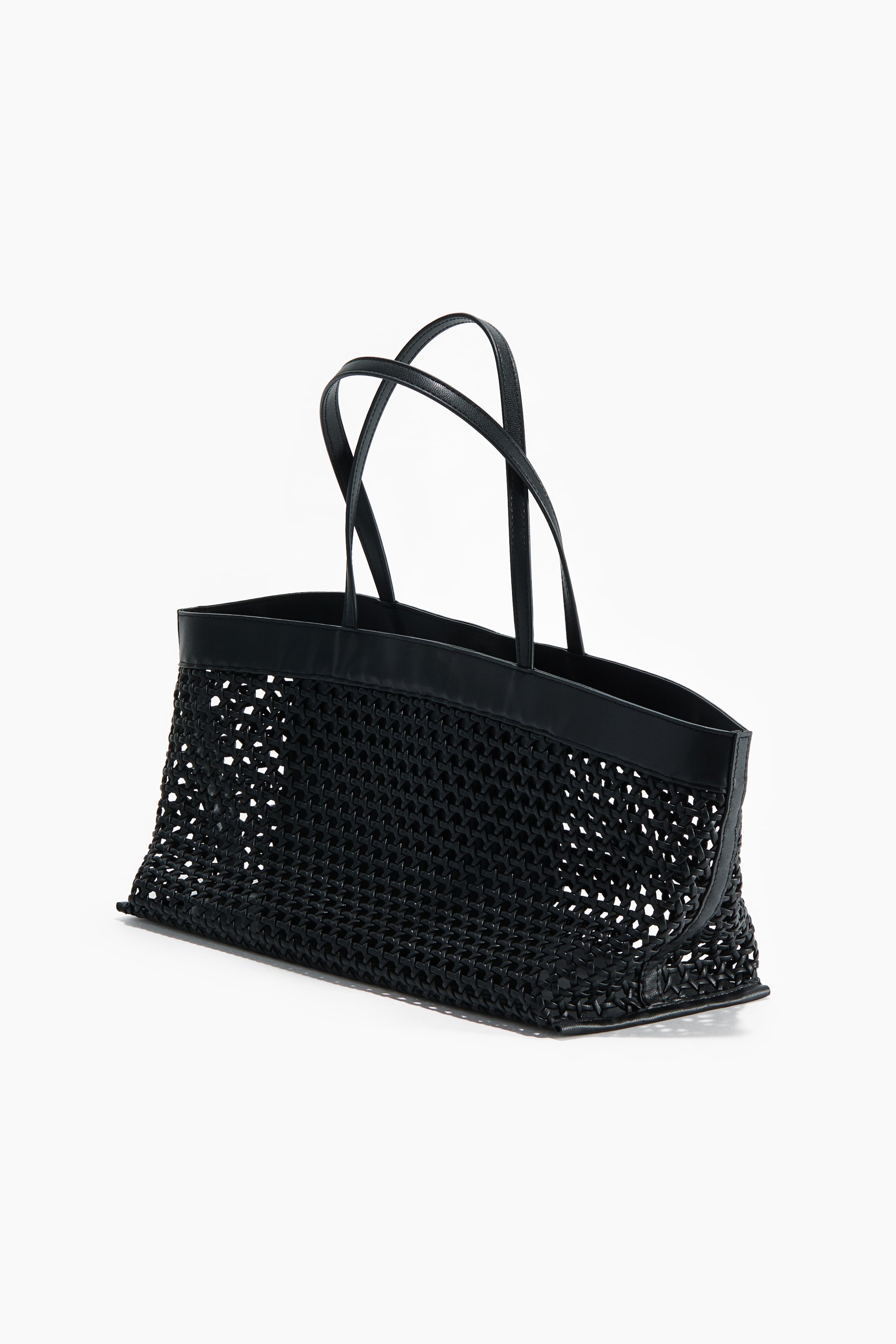 View larger image: A black shopper bag is showcased from a front-side perspective, highlighting a lattice weave design in coated fabric, two arched handles, and a solid top rim.