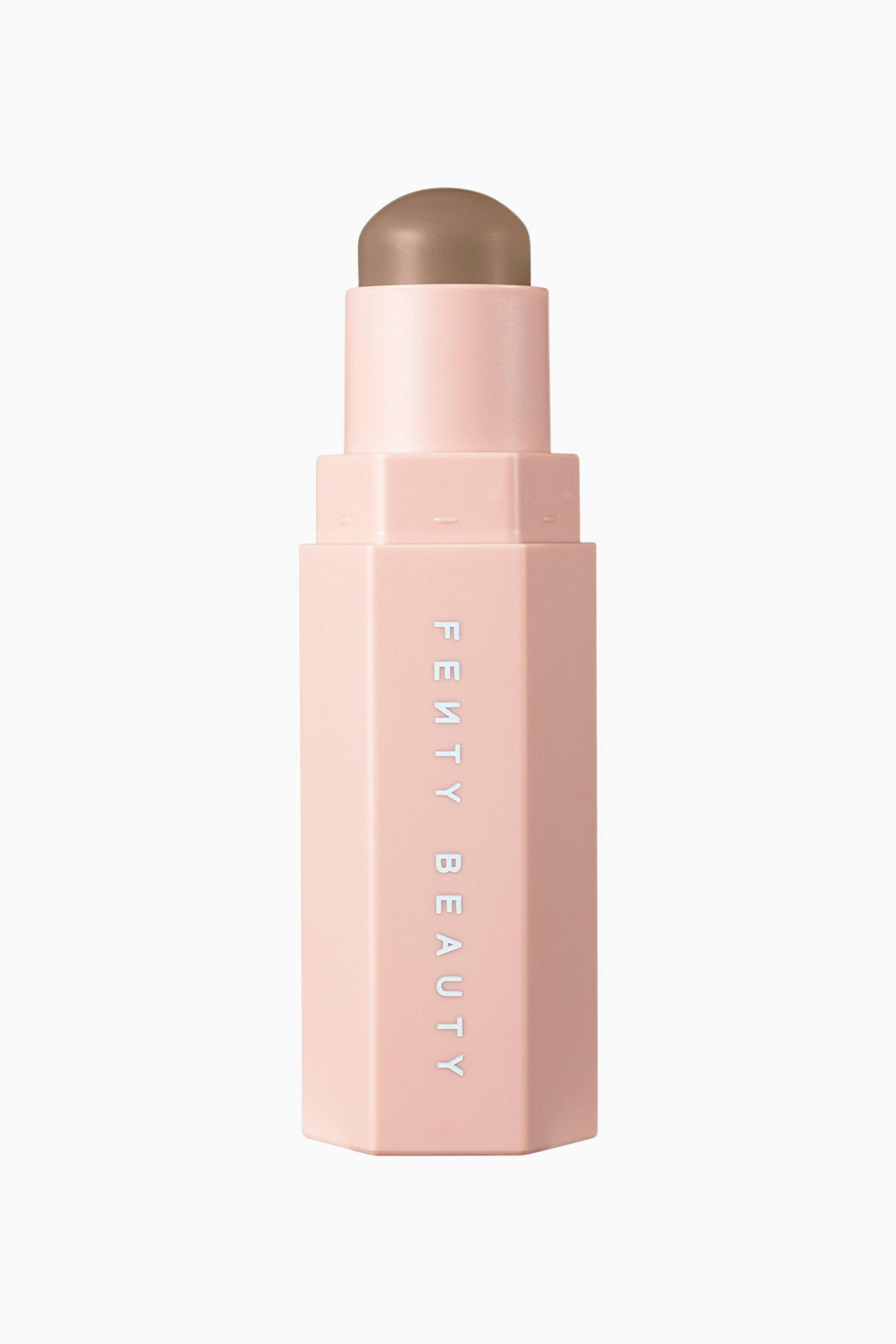Näytä suurempi kuva: Kuusikulmainen, mattapintainen vaaleanpunainen contour-stick-kynä seisoo pystyasennossa ja esittää viileän sävyistä ruskeaa cream-tuotetta, jonka yläosasta ulkonee pyöristetty kupolimainen kärki. Kotelon etupuolen sivulla näkyy brändin nimi "FENTY BEAUTY" valkoisilla suuraakkosilla pystysuunnassa painettuna.
