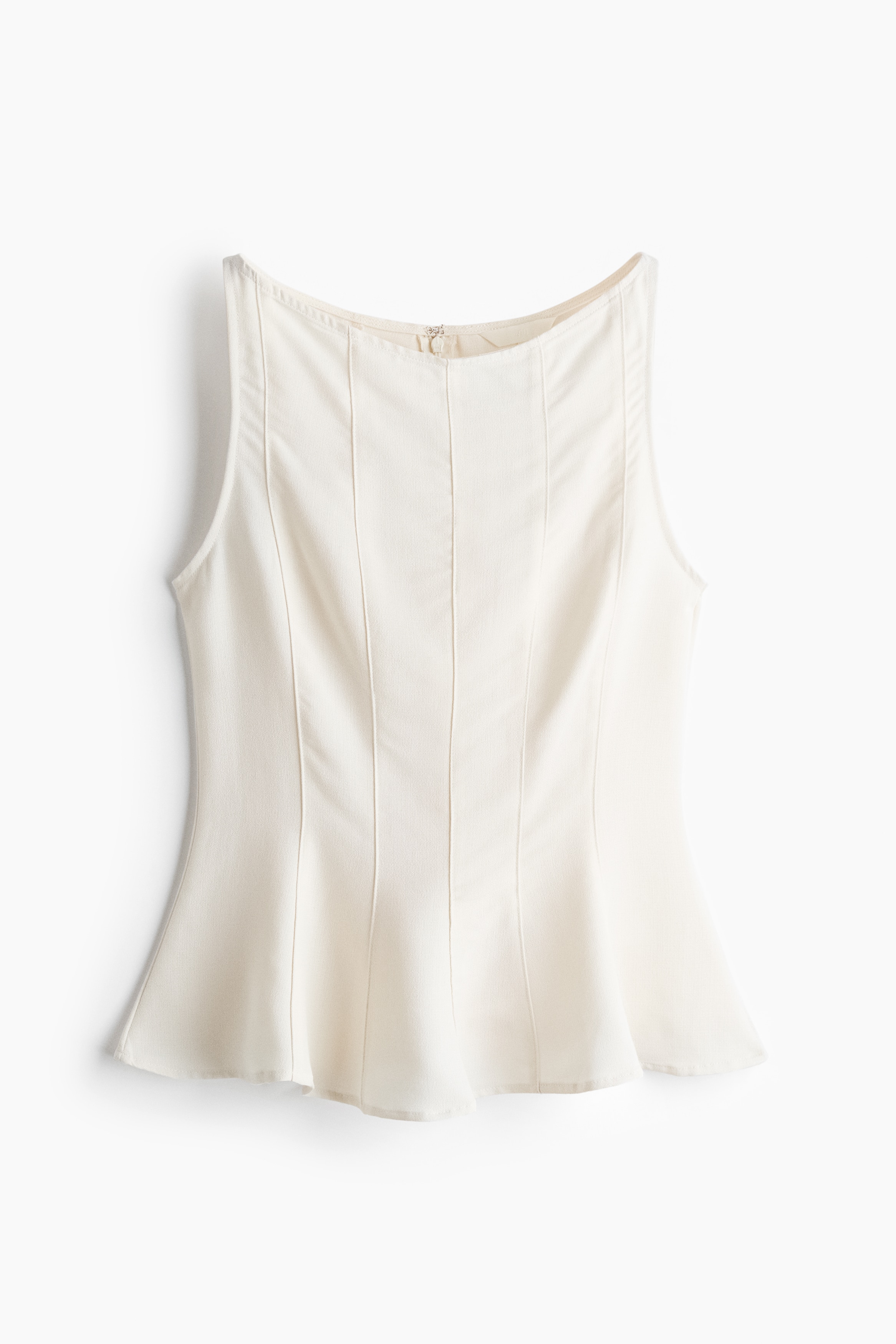 A sleeveless, cream-coloured peplum top is shown from the front, highlighting its structured bodice with prominent vertical seam detailing. The top features a high scoop neckline and a flared hem that creates a gentle wave pattern at the bottom.