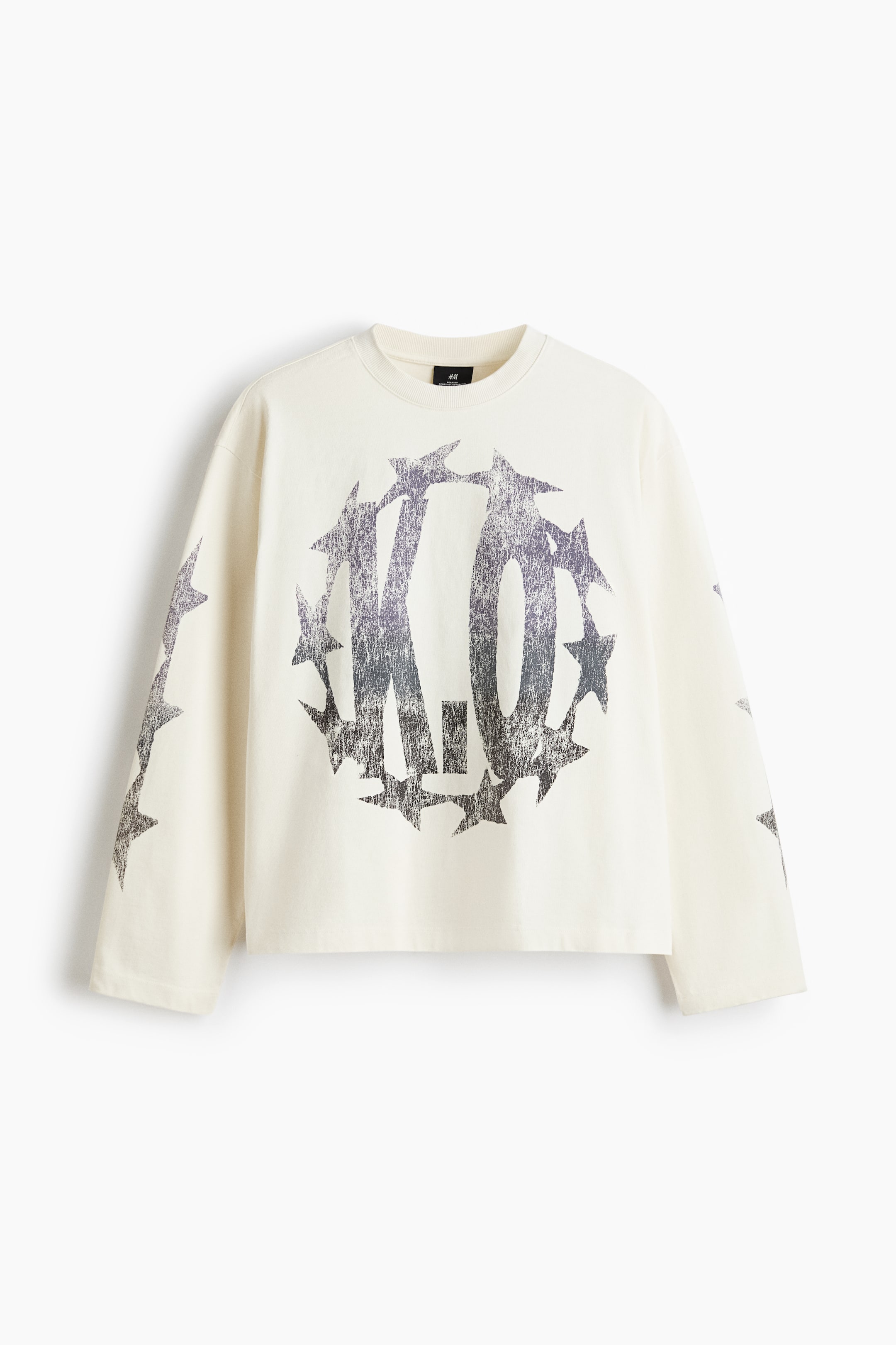 View larger image: A cream long-sleeved crewneck T-shirt features a large, distressed "K.O." graphic encircled by stars on the front, with additional distressed star graphics along both sleeves.