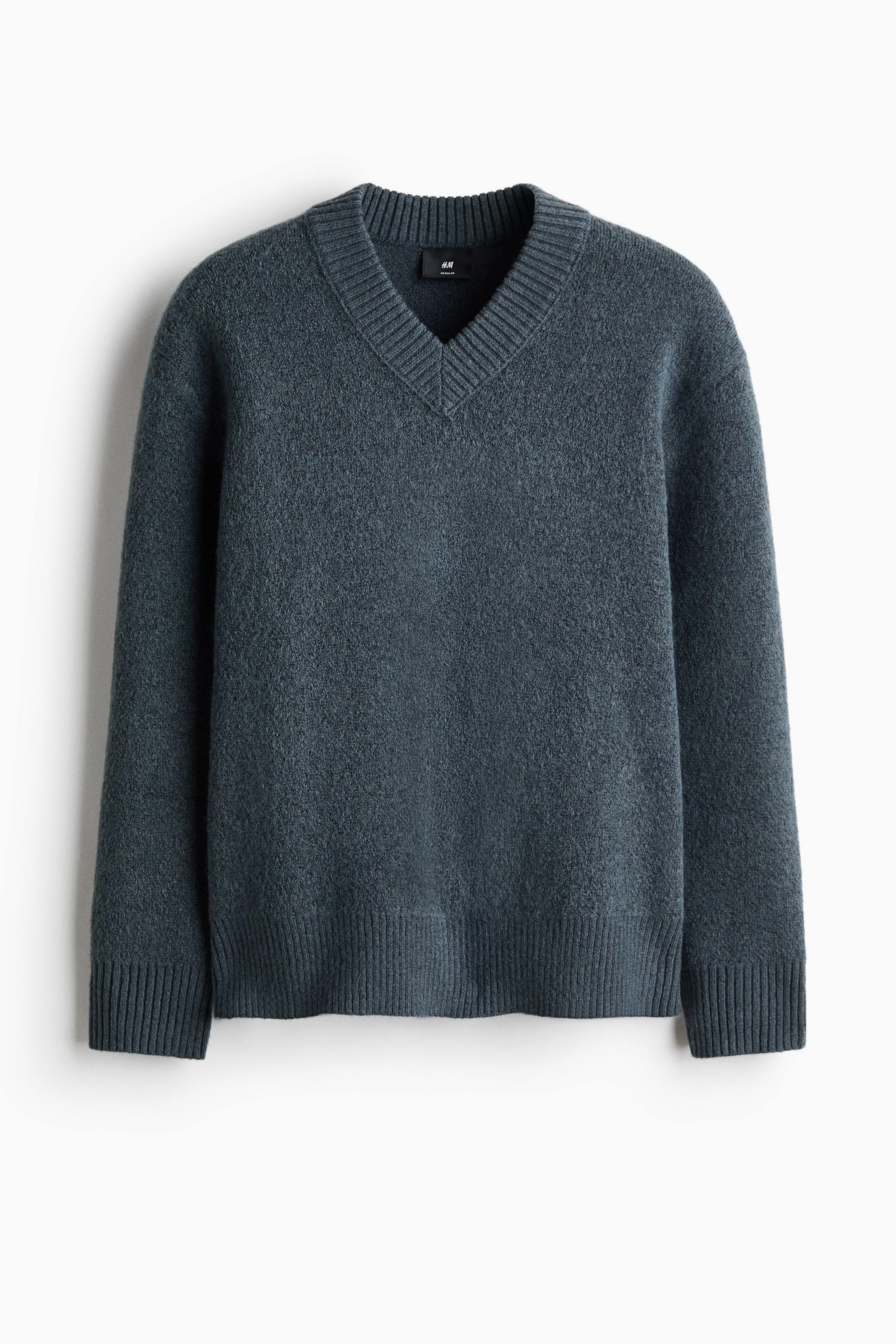 View larger image: A dark teal sweater is shown front-facing, featuring a fuzzy texture, a ribbed V-neck, long sleeves, ribbed cuffs, and a ribbed hem.