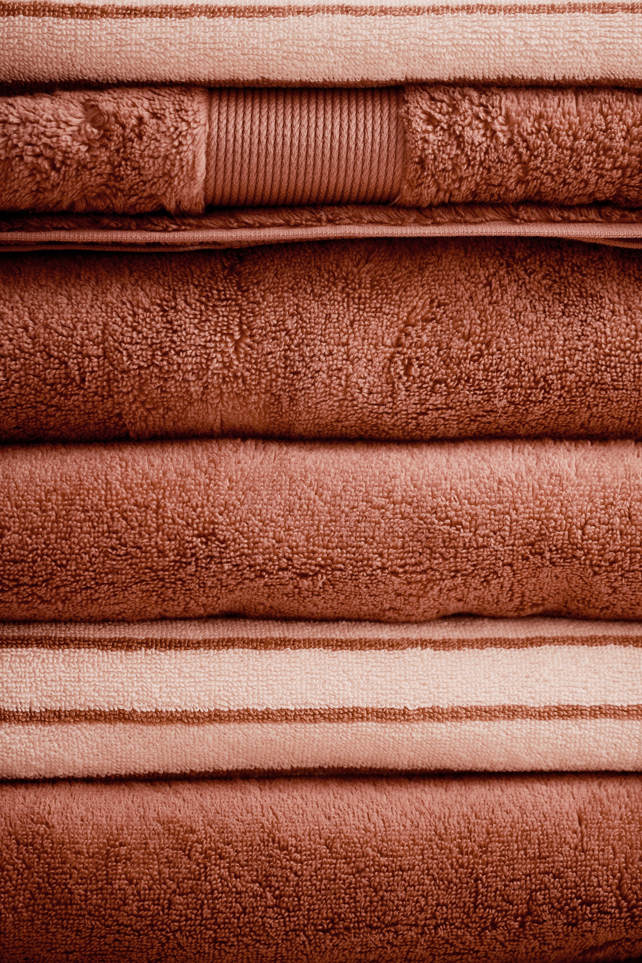 View larger image: The towels are featuring terry cloth textures, with some displaying stripes and one presenting a distinct vertical ribbed band.