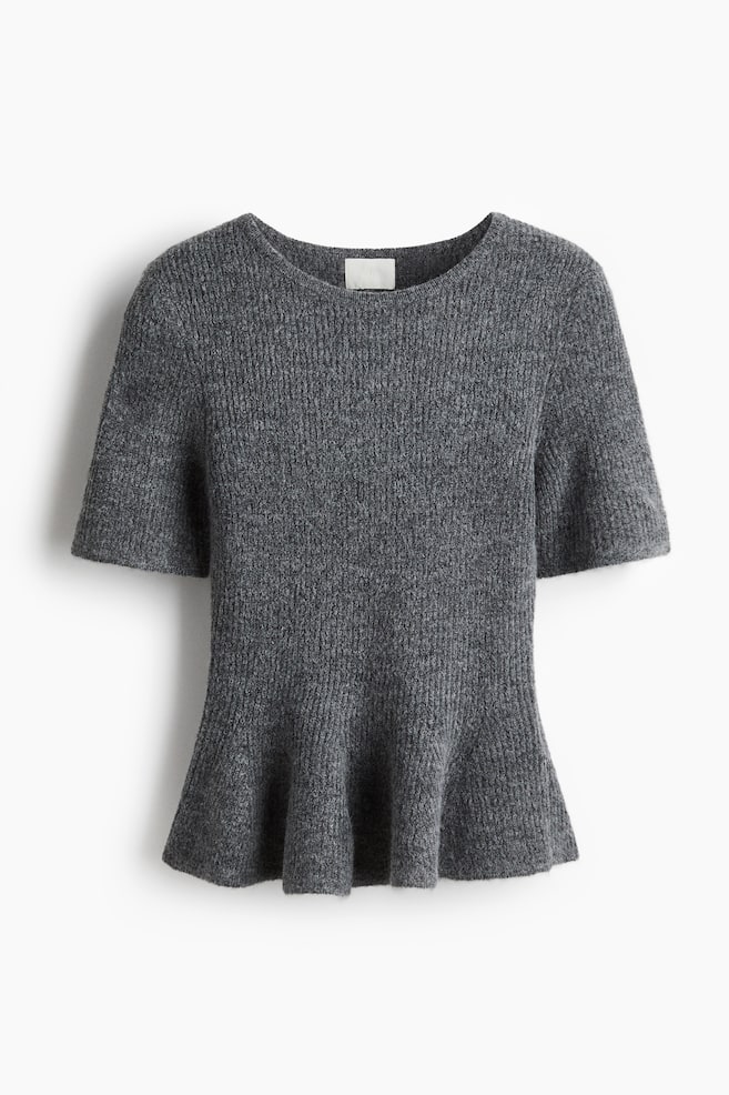A grey knitted top is displaying from the front, featuring a ribbed texture, a round neckline, and short sleeves. The top's body is fitted before flaring out into a peplum hem. - 1
