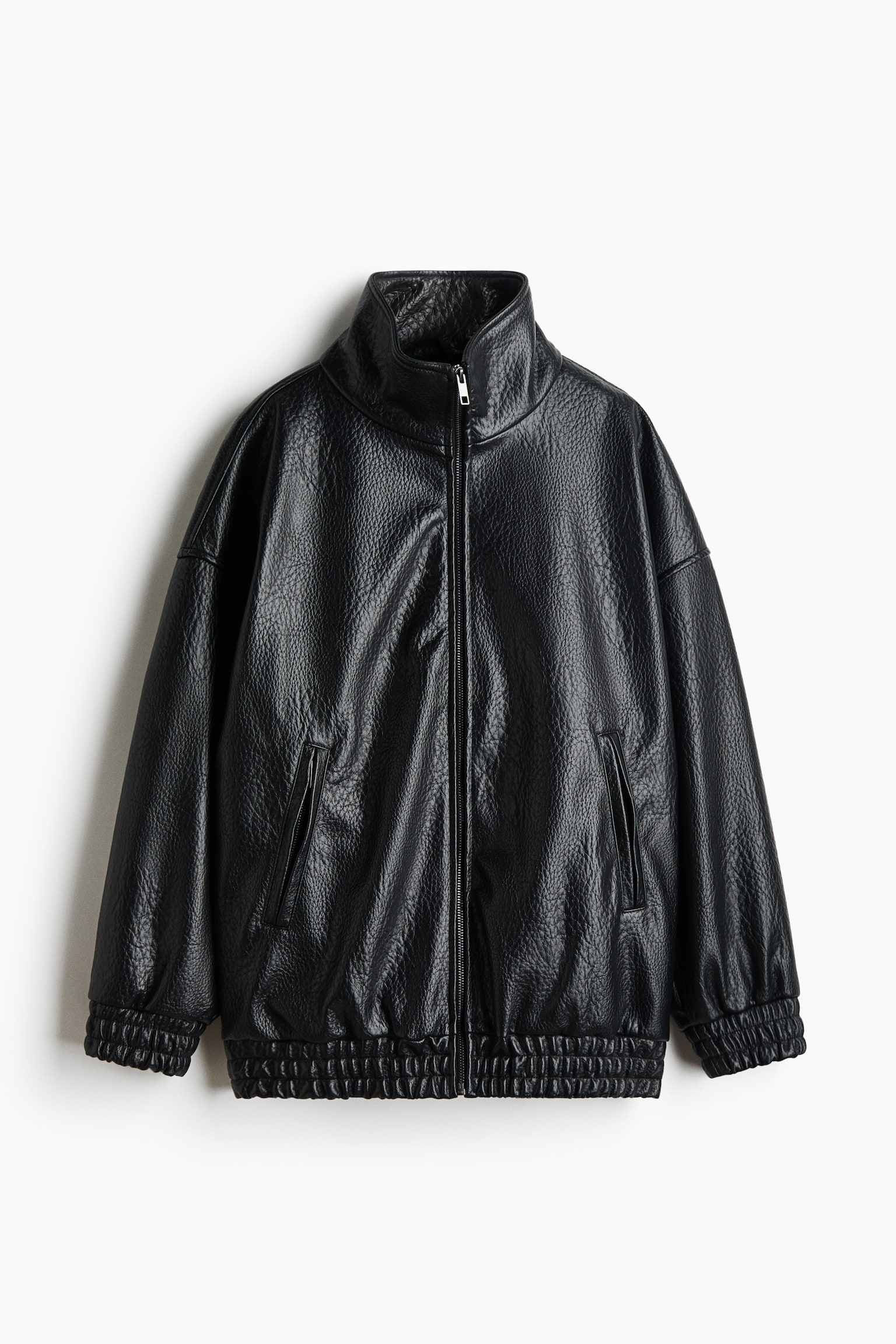 A black, textured leather jacket is shown from the front, featuring a high stand-up collar and a full-length zip closure. The jacket features dropped shoulders, side welt pockets, and elasticated, ruched detailing at the cuffs and hem.