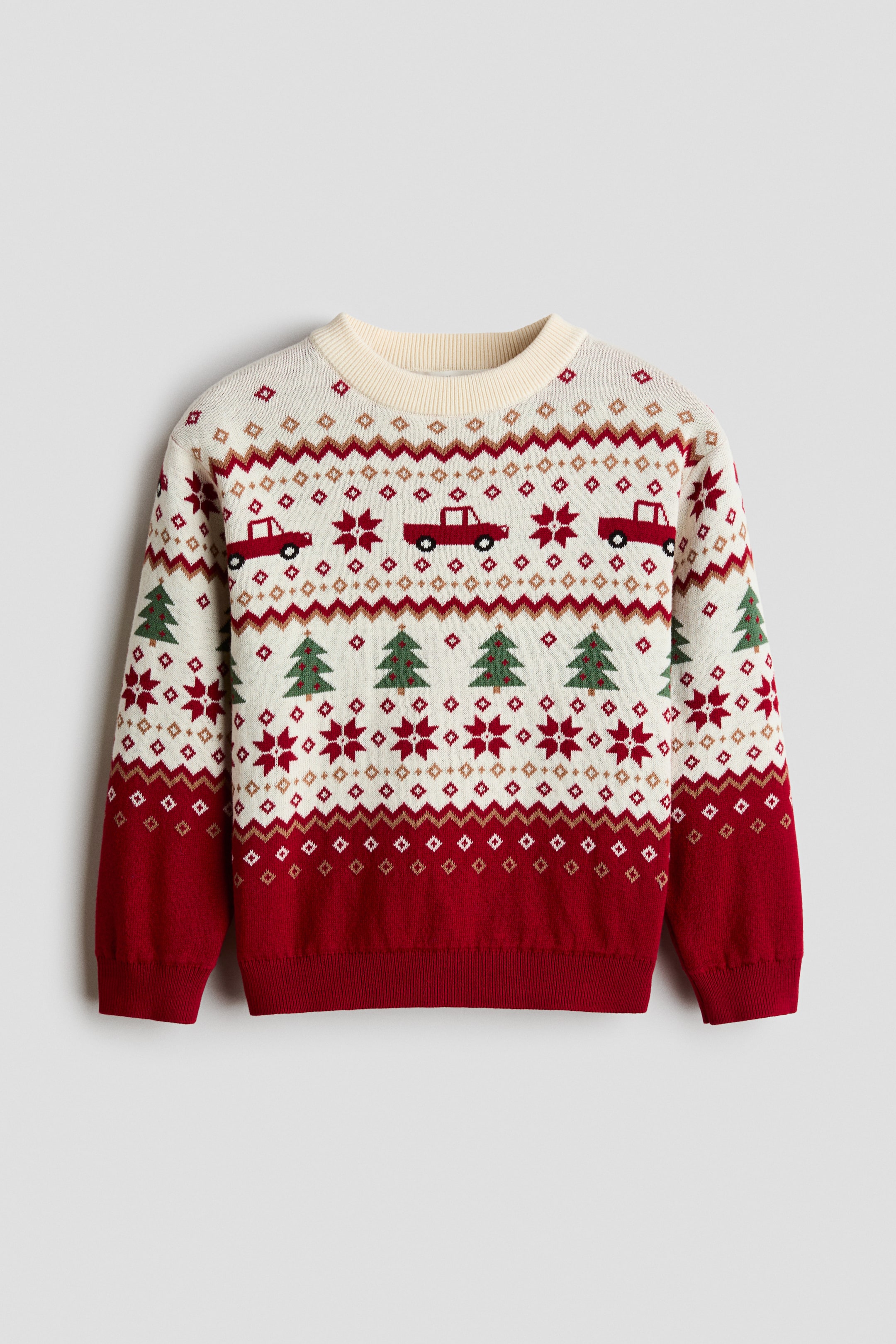 Agrandir l'image: Un pull en tricot jacquard est présenté de face, avec un motif de style Fair Isle en crème et rouge composé de bandes horizontales de pick-ups rouges, de sapins verts et de motifs géométriques en forme de flocon de neige. Le pull est doté d'un col rond côtelé de couleur crème, d'épaules tombantes et de manches longues terminées par des poignets côtelés rouges assortis à l'ourlet côtelé.