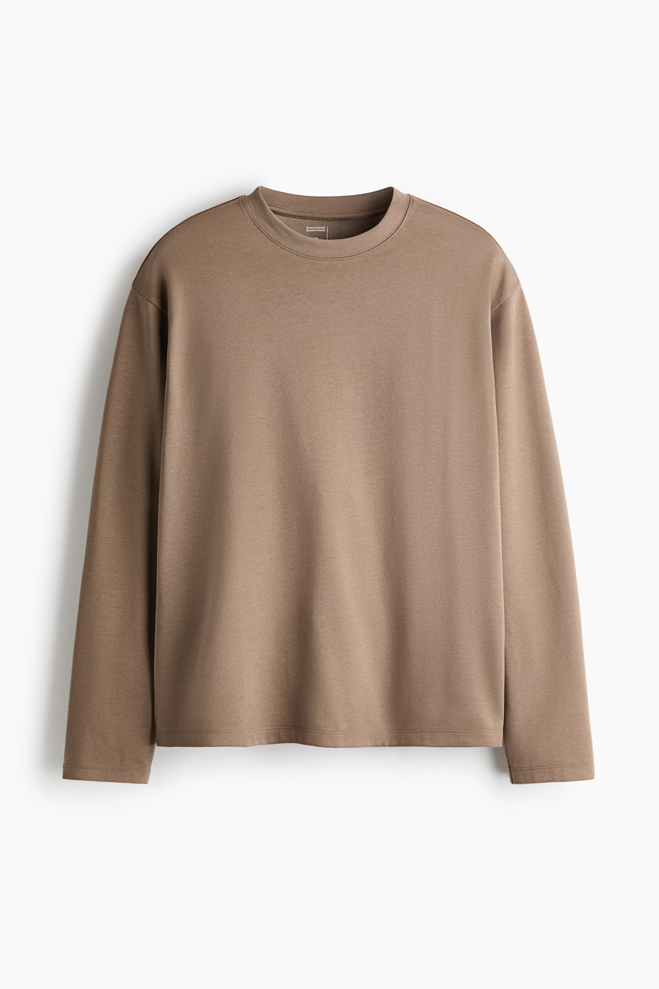 Visa större bild: En långärmad t-shirt med avslappnad passform i en taupebrun nyans visas framifrån och framhäver den ribbade runda halsringningen, de nedhasade axlarna och den raka fållen.