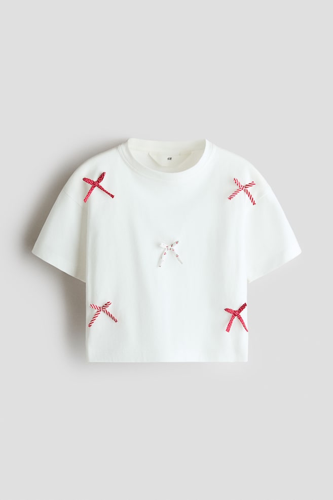 T-Shirt aus Baumwolle mit Applikationen - Weiß/Rot/Elfenbein/Spread love/Cremefarben/Schleife/Korallenrosa/Le Marais/Hellrosa/Gestreift/Elfenbein/New York/Weiß/Marineblau gestreift/Elfenbein/Blumen/Hellrosa/Schleifen - 1