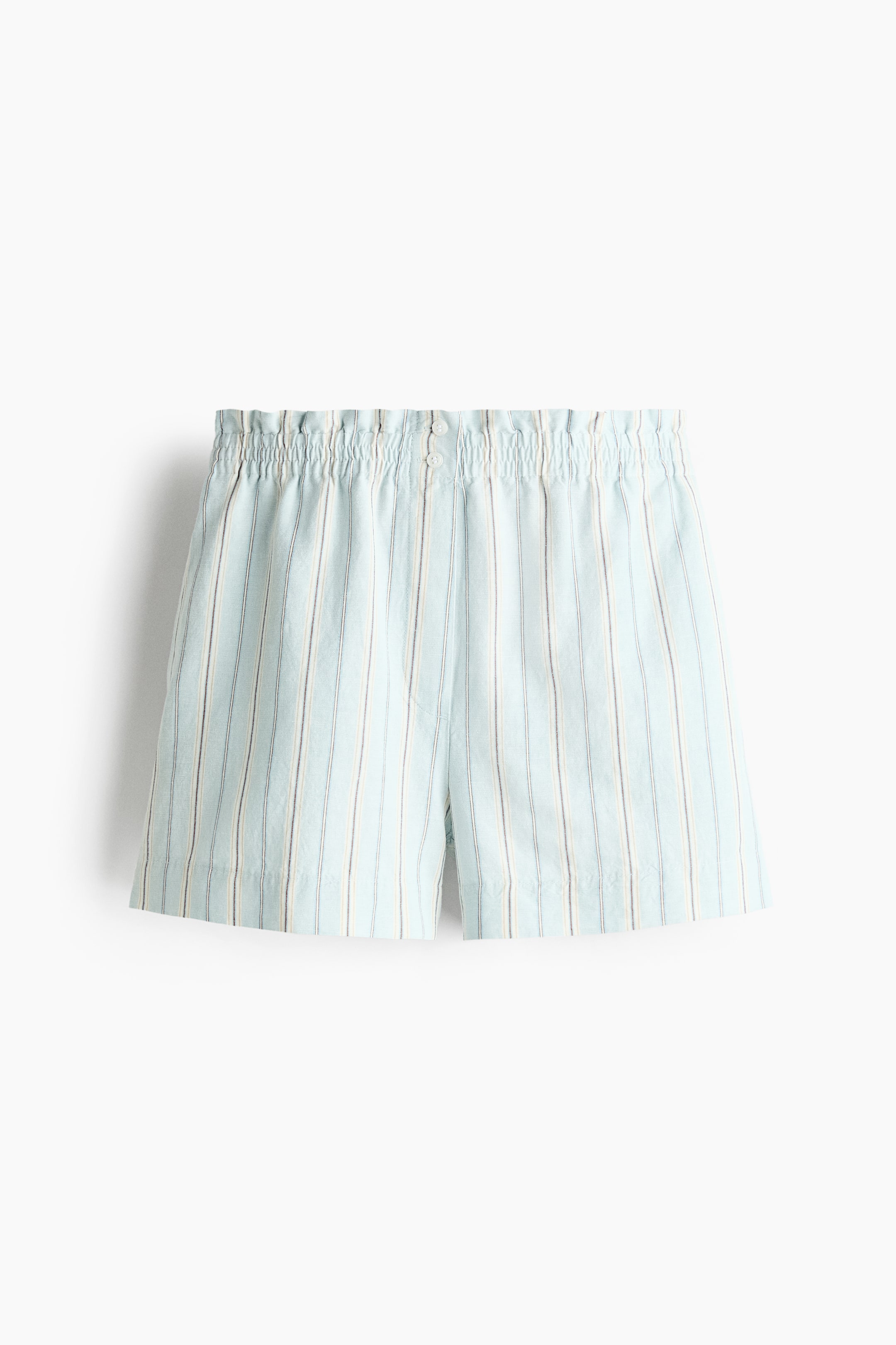 View larger image: The shorts showcase a light blue fabric adorned with vertical white and thin dark grey stripes. They feature an elasticated, gathered waistband with two small buttons at the front.