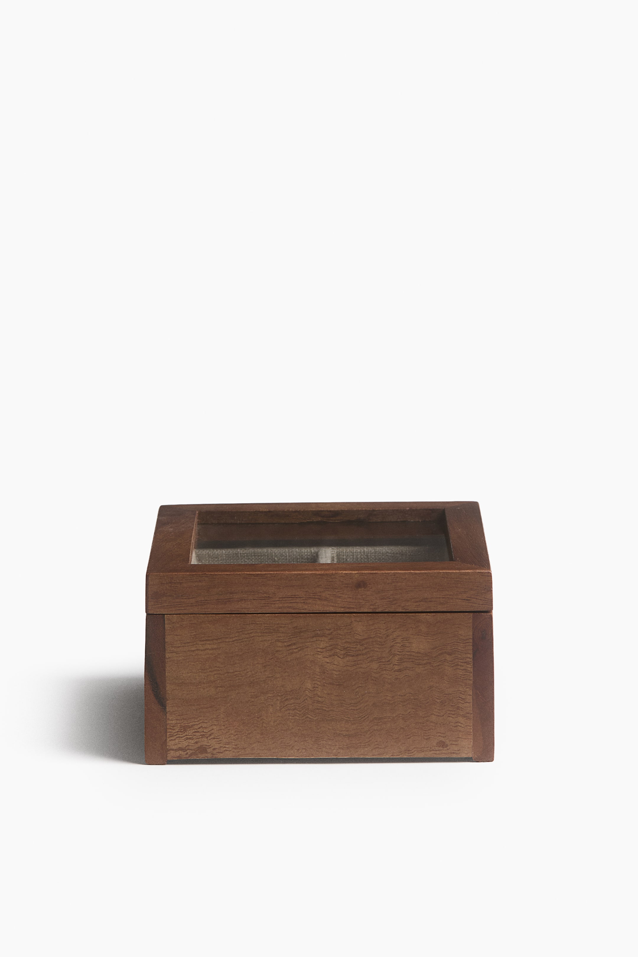 View larger image: A rectangular wooden box is facing the front, showcasing a medium-brown finish with visible wood grain. The box features a glass-paneled lid, revealing a partitioned interior lined with light grey fabric.