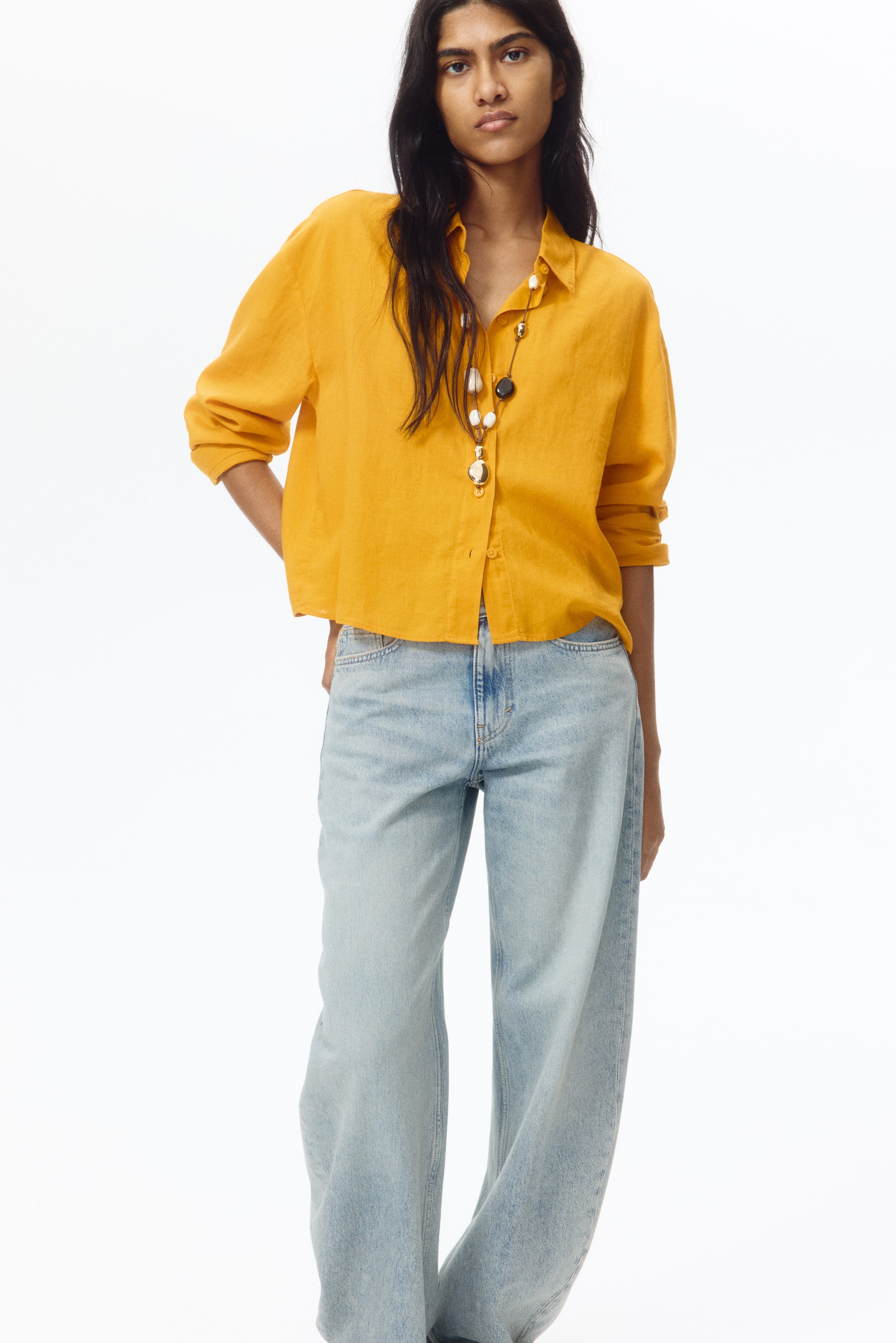 View larger image: Light blue wide-leg jeans are facing front, featuring a high-waisted design and a relaxed fit, with a visible front button and zipper closure.