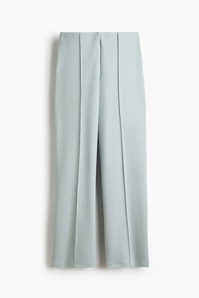 Pantalon vert menthe pâle présentant une coupe droite avec des coutures verticales en pince courant le long de l'avant de chaque jambe. Le pantalon est doté d'une ceinture plate et d'ourlets simples. - 1