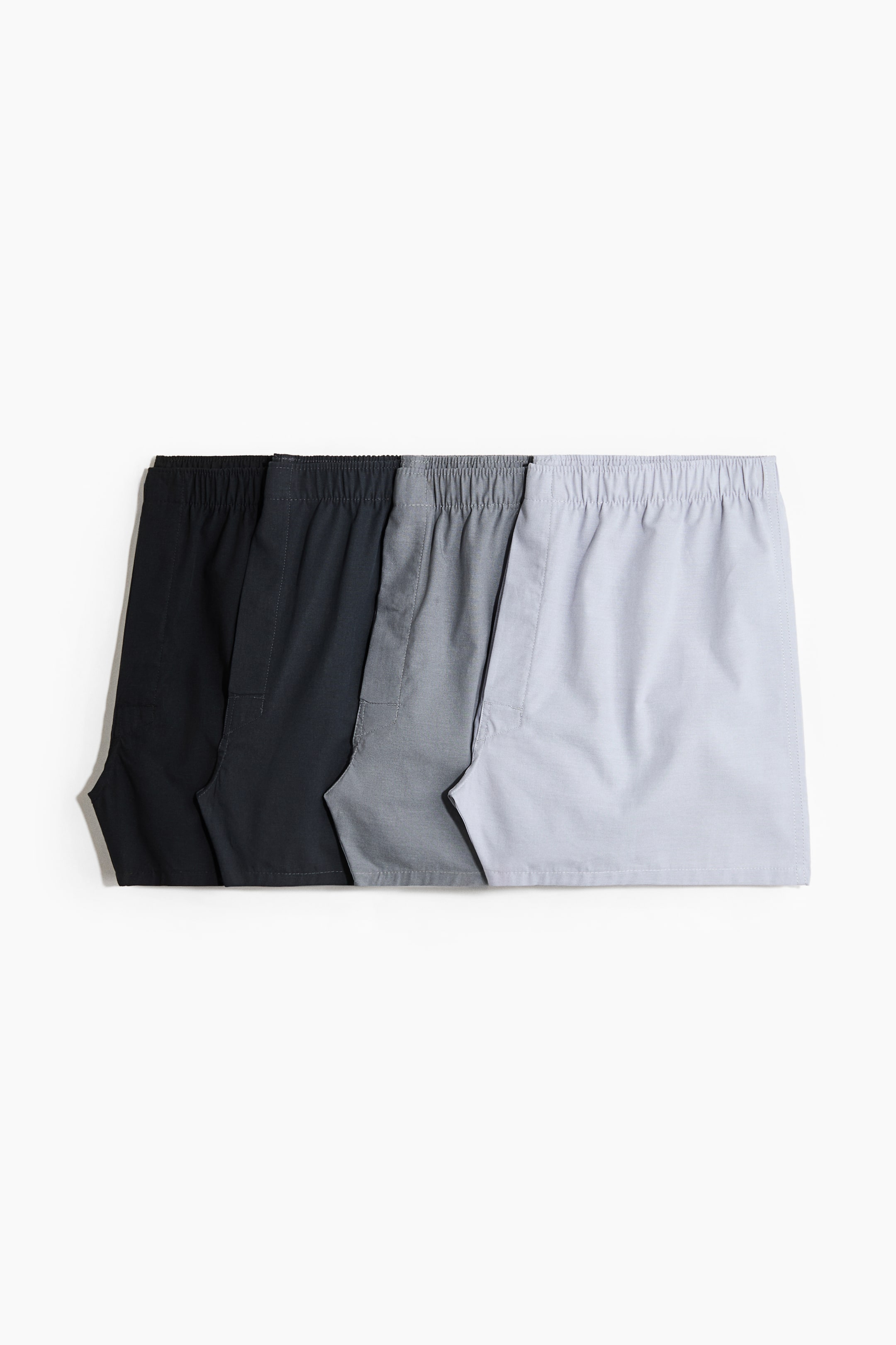 View larger image: Four pairs of boxer shorts are displayed in a gradient from black to light grey, each boasting a soft weave, an elasticated waistband, long legs, and a button fly at the front.