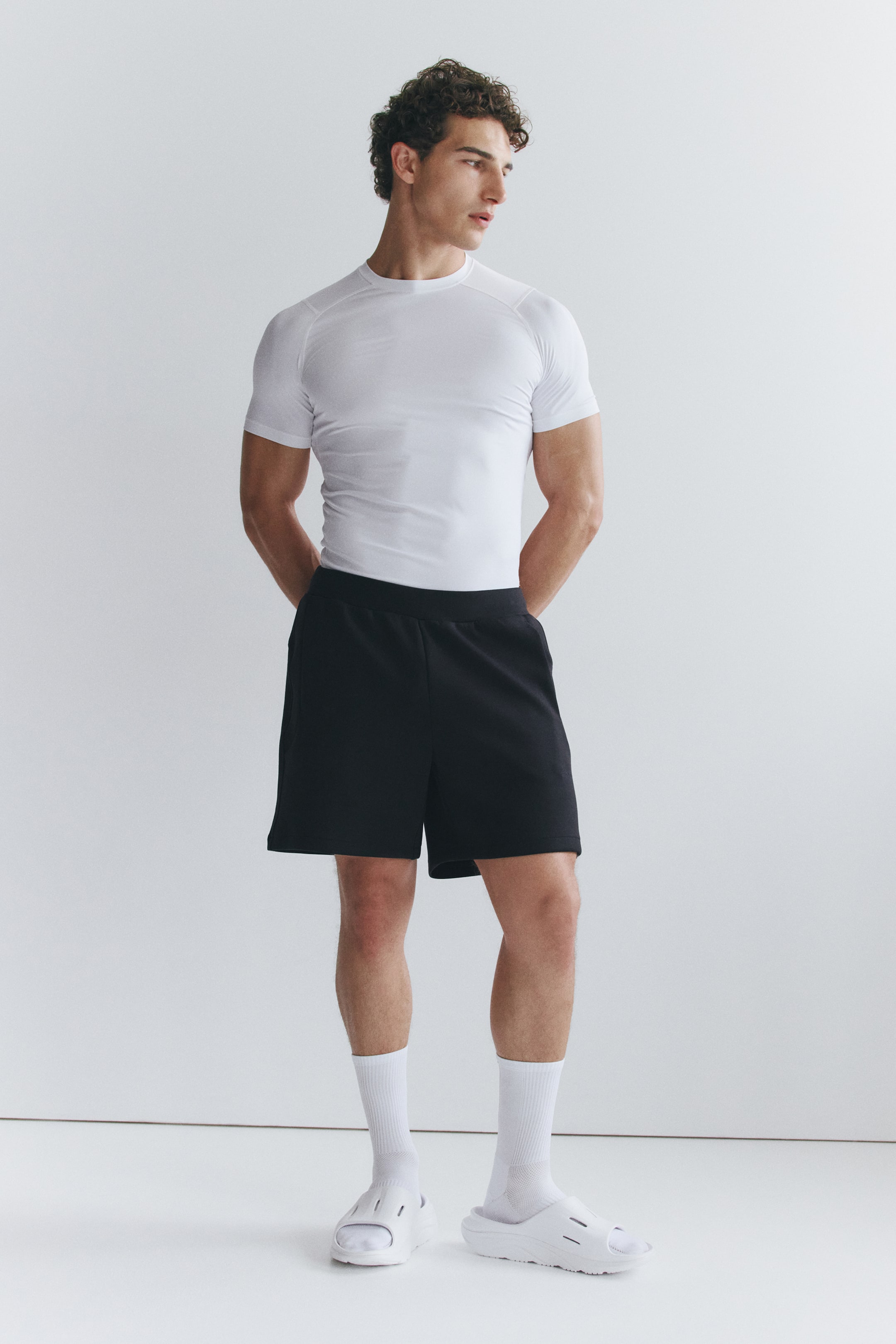 Visa större bild: Modellen bär en vit Compression Fit Sports T-shirt med DryMove?, som har en rund hals, korta raglanärmar och en tajt passform som formar sig efter överkroppen.