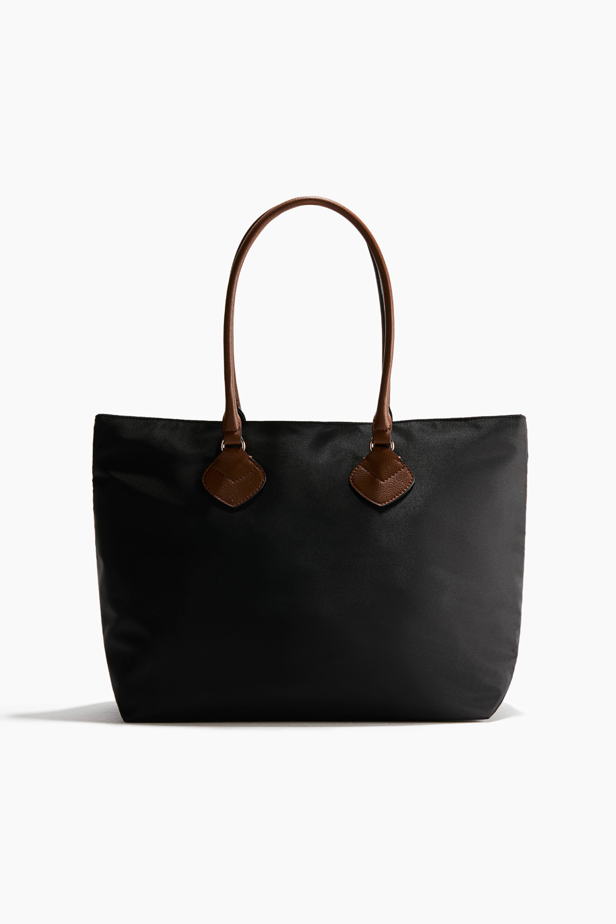View larger image: A black shopper bag in woven fabric is shown front-facing, featuring brown tubular handles in coated fabric attached with diamond-shaped patches.